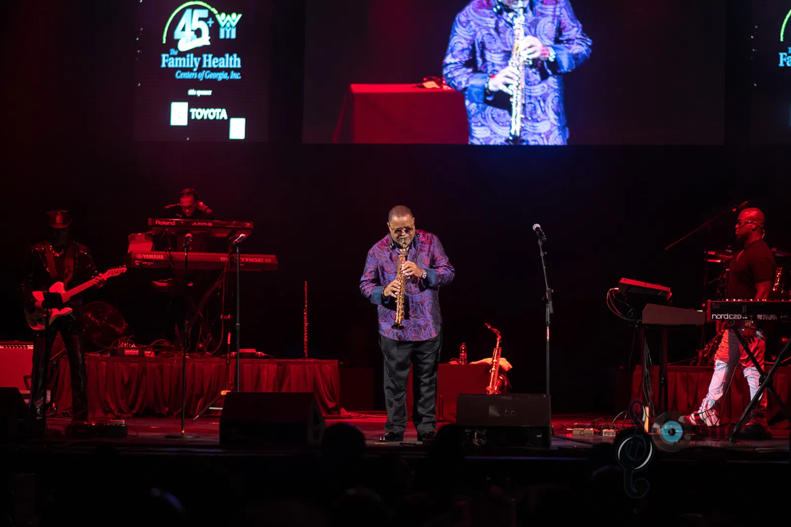 a man on a stage in front of a television playing a video game