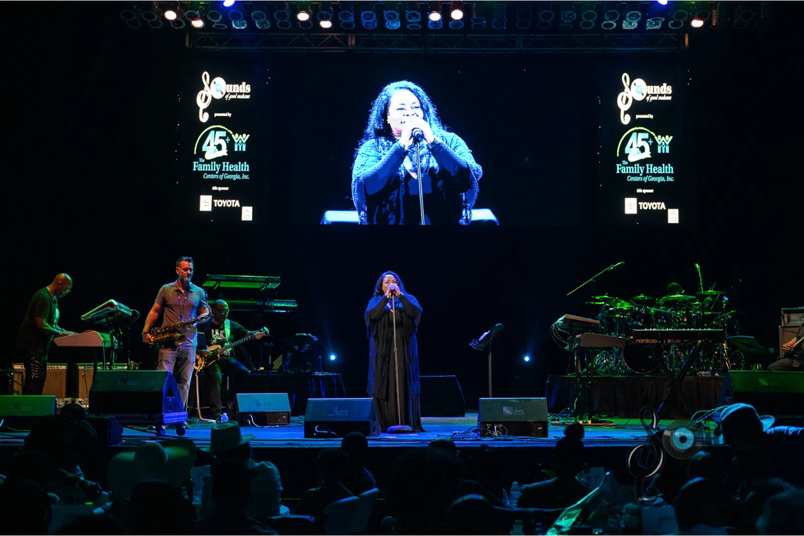 a group of people playing instruments and performing on a stage