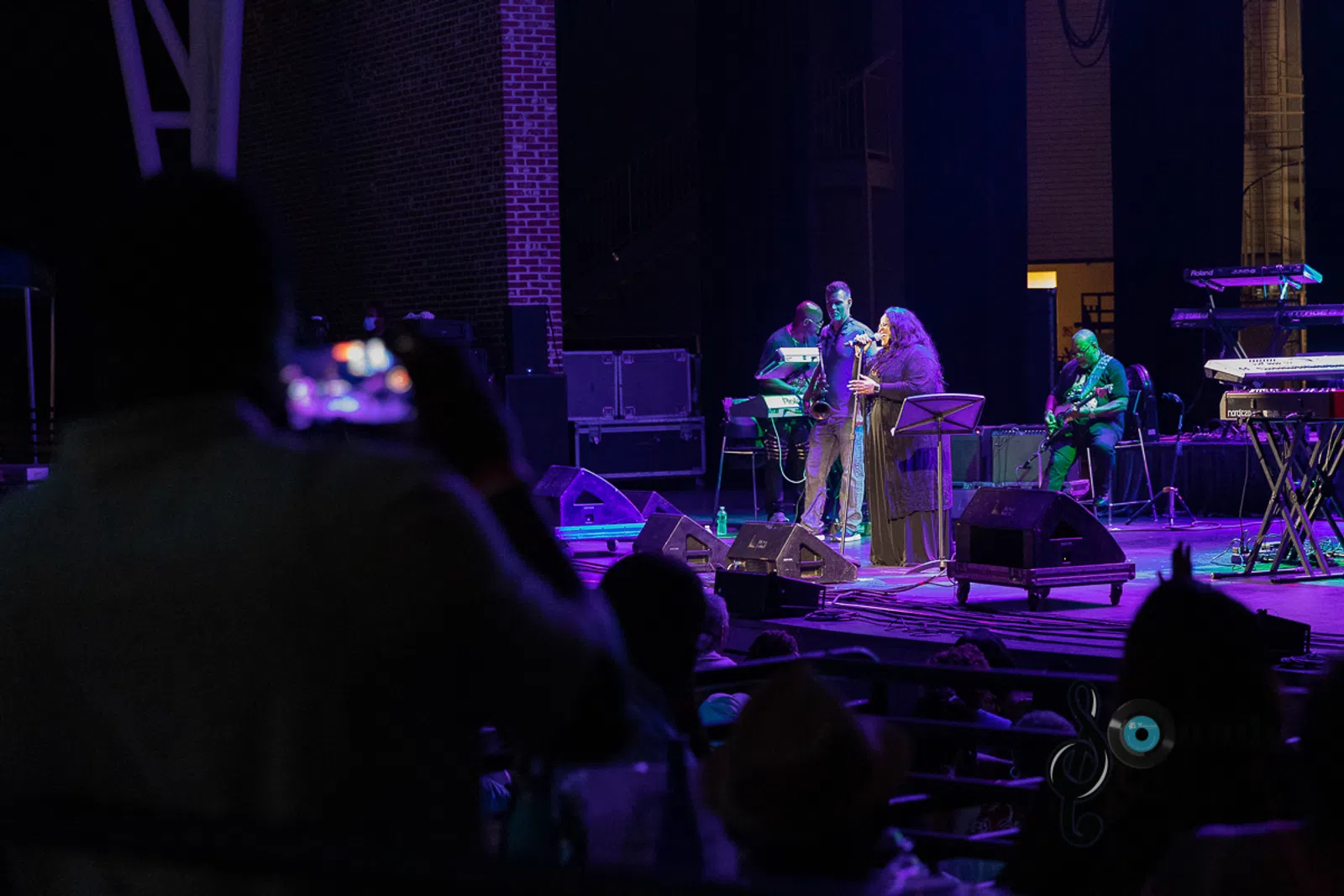 a group of people sitting at a table in front of a stage