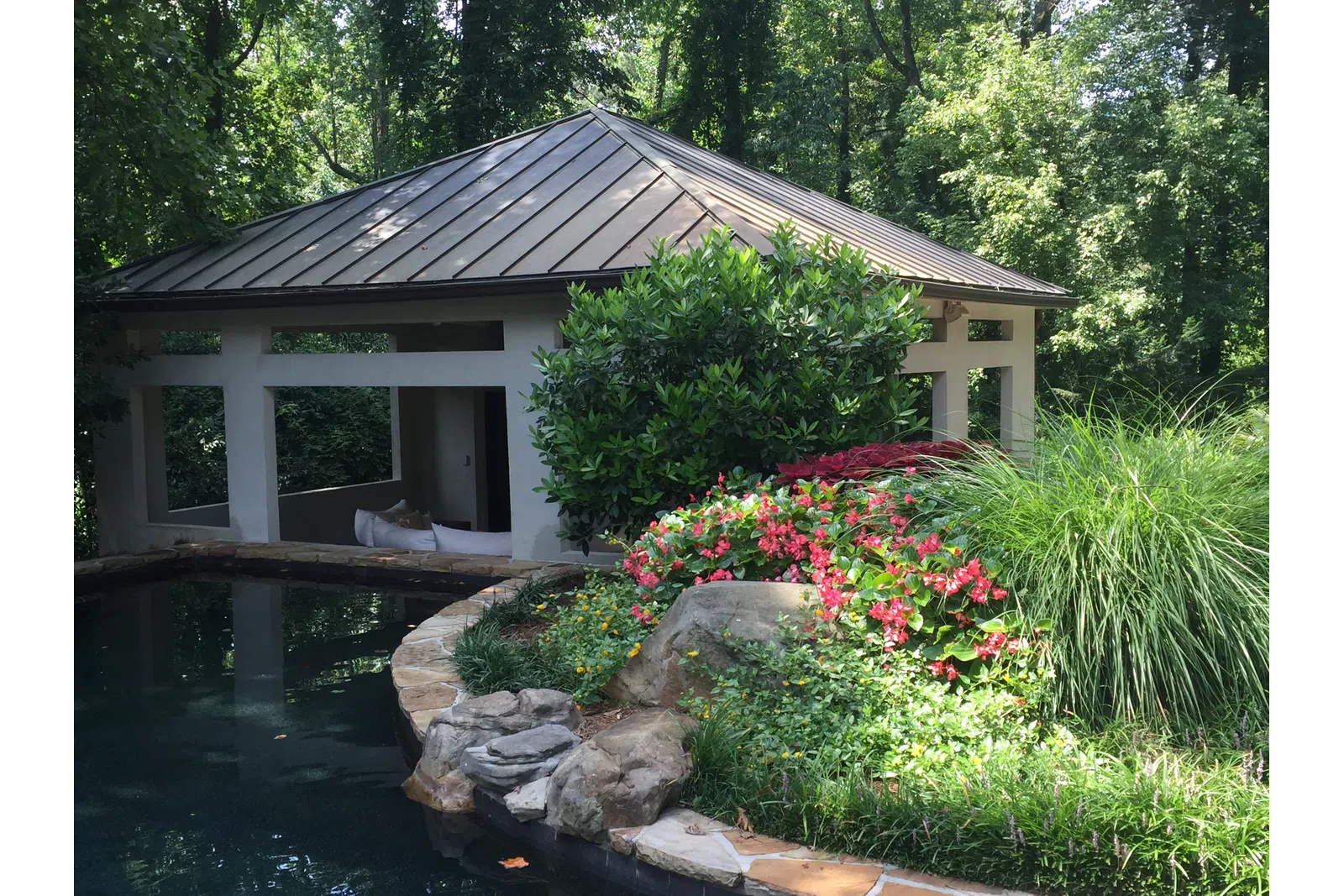 a house with a pond and flowers