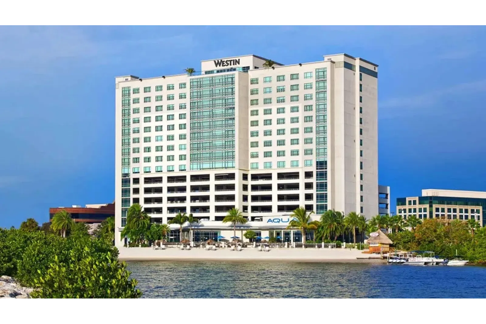 a large white building next to a body of water