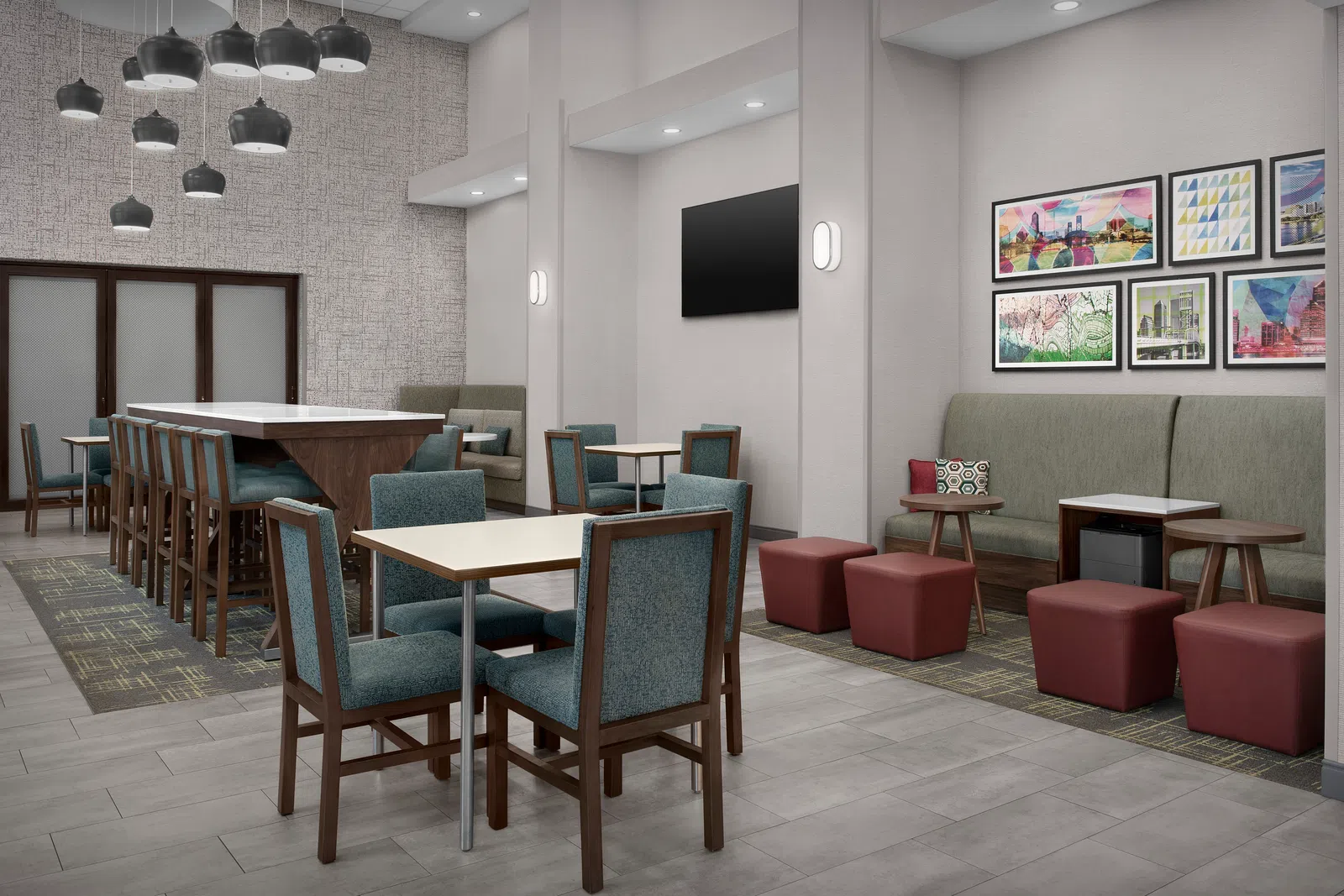Modern hotel lobby with seating areas, pendant lights, artwork on walls, and neutral tones in furniture and flooring