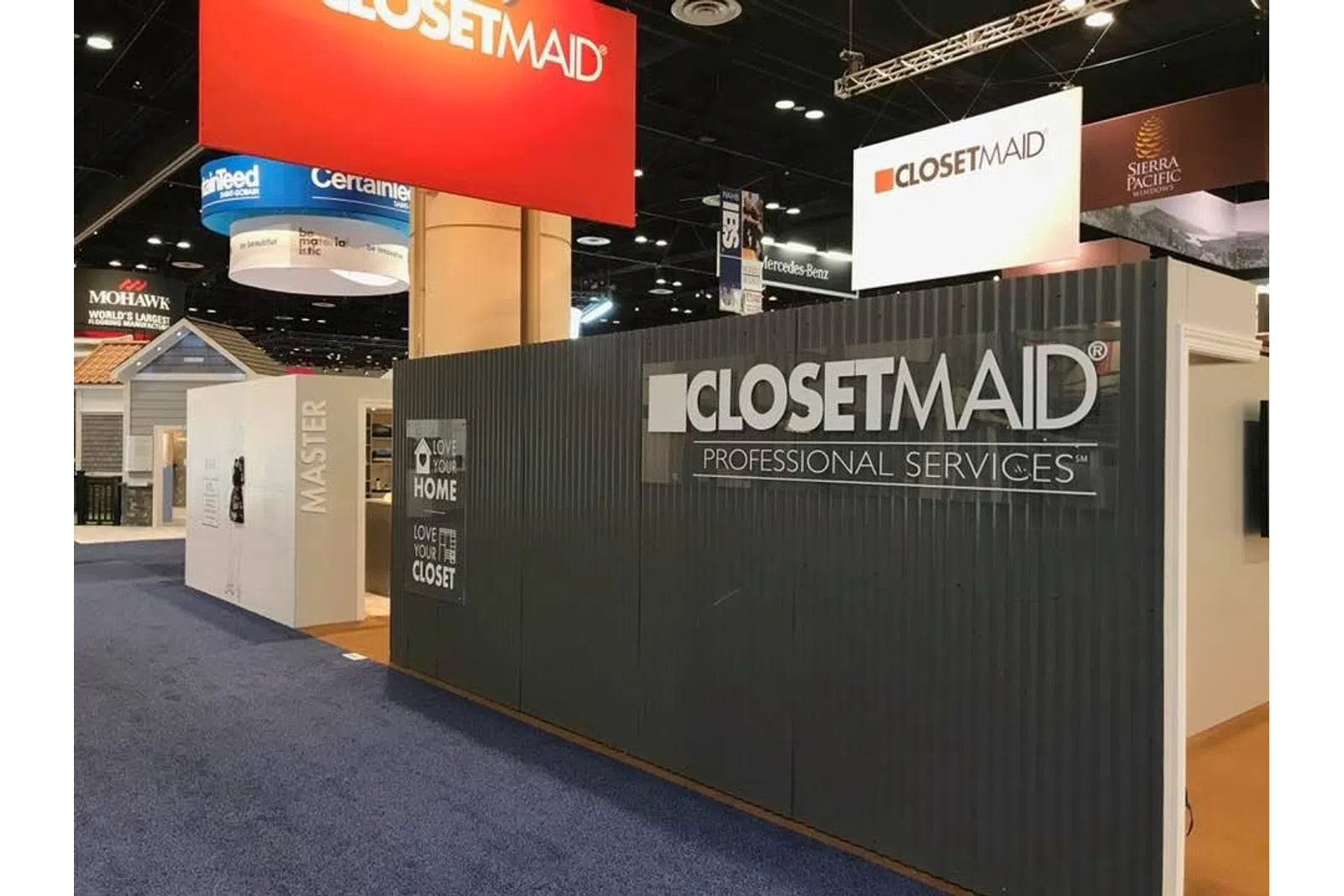 ClosetMaid professional services booth at a trade show with branded signage and product displays.