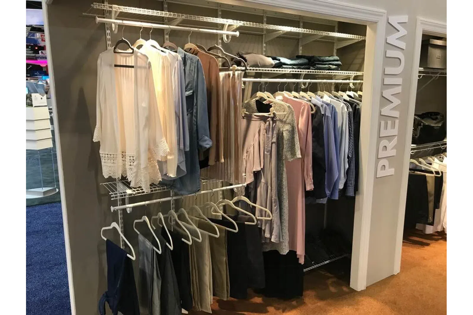 Closet organizer displaying neatly hung clothes in neutral tones labeled as premium wear