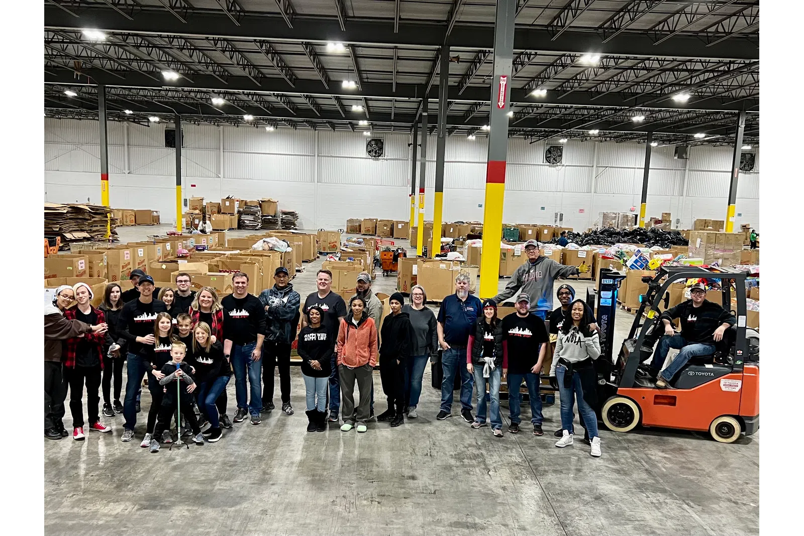 a group of people posing for a photo in a warehouse