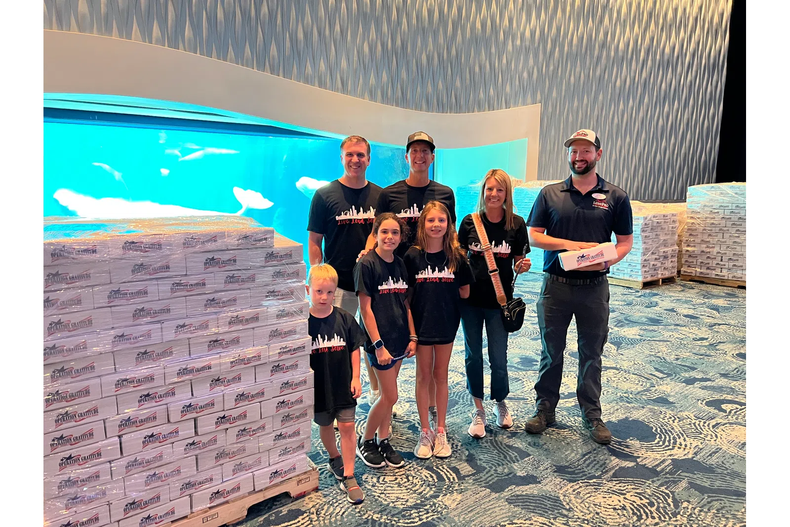 a group of people posing for a photo in front of a large poster