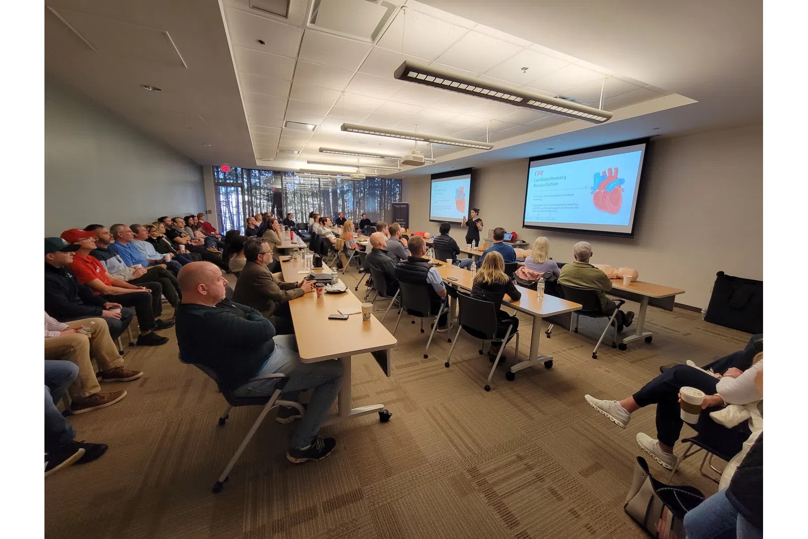 a group of people sitting in a room with a projector screen