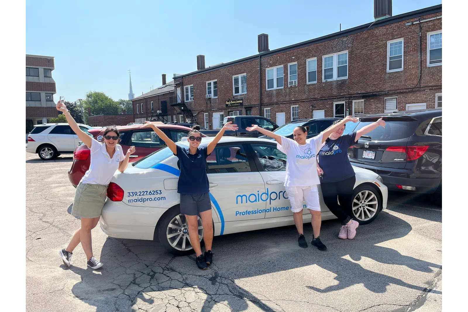 a group of people posing in front of a car