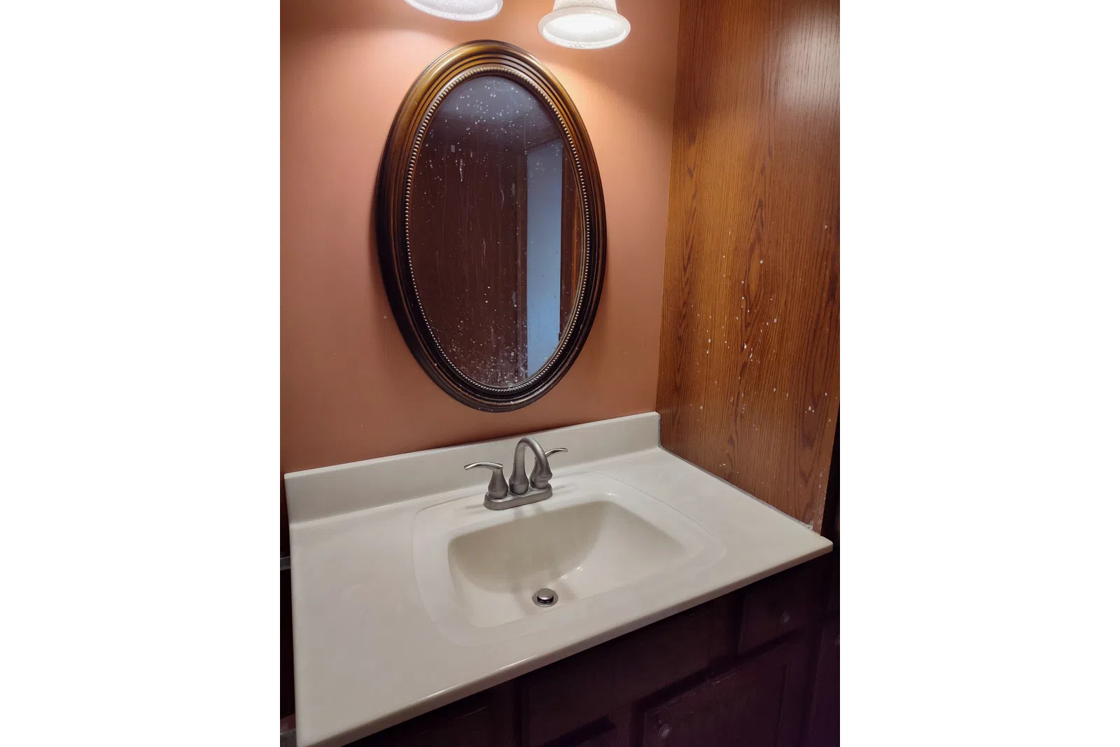 a bathroom sink with a round mirror