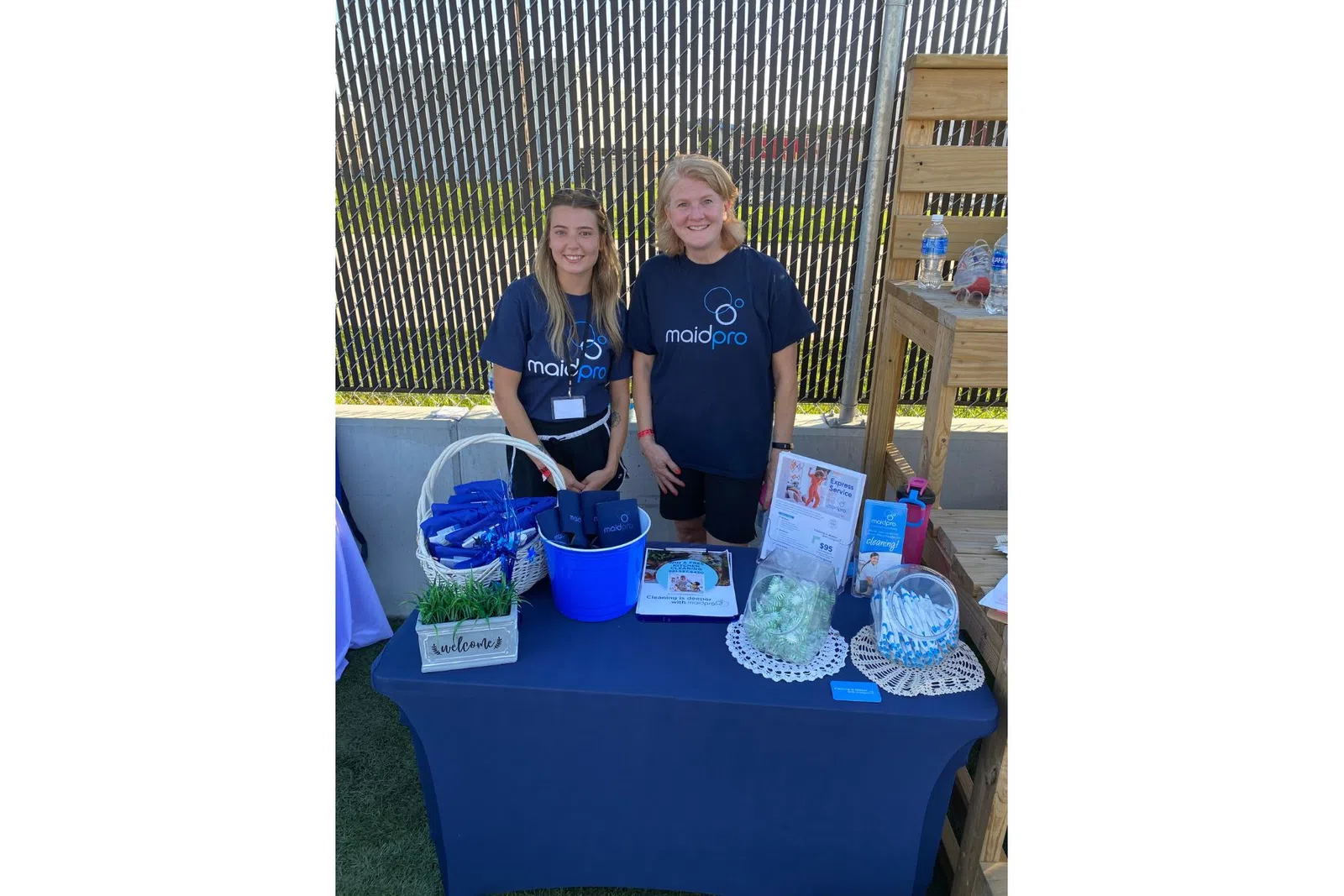 a couple of women standing next to a table with food and drinks