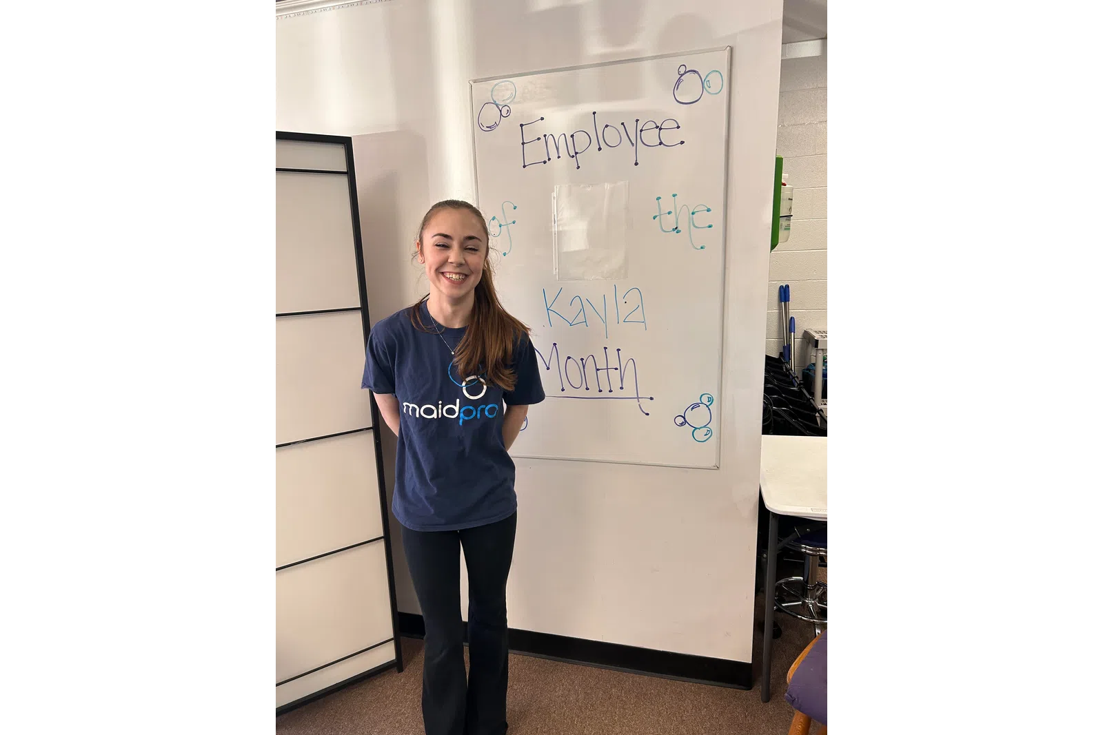 a person standing next to a white board with writing on it