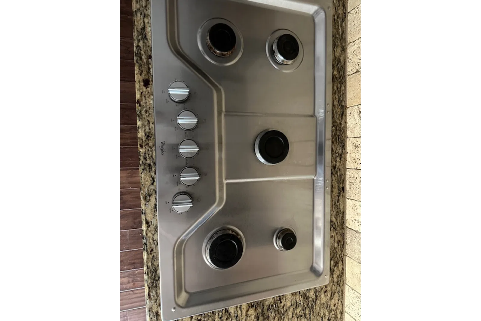 a silver rectangular object with buttons and knobs on a counter