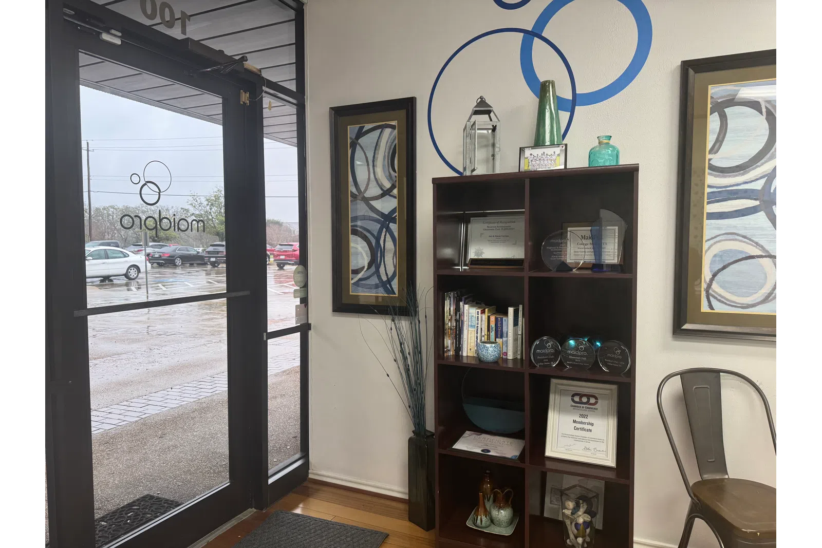 a room with a book shelf and a window with a view of a street and cars