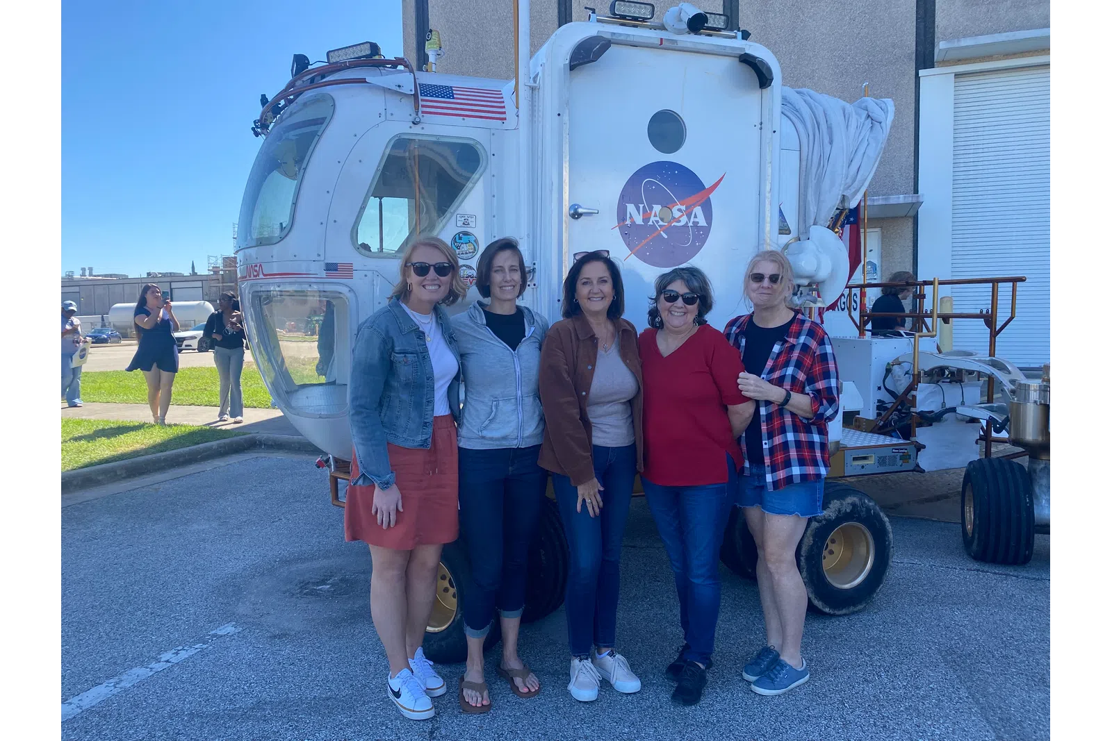 a group of women standing in front of a food truck