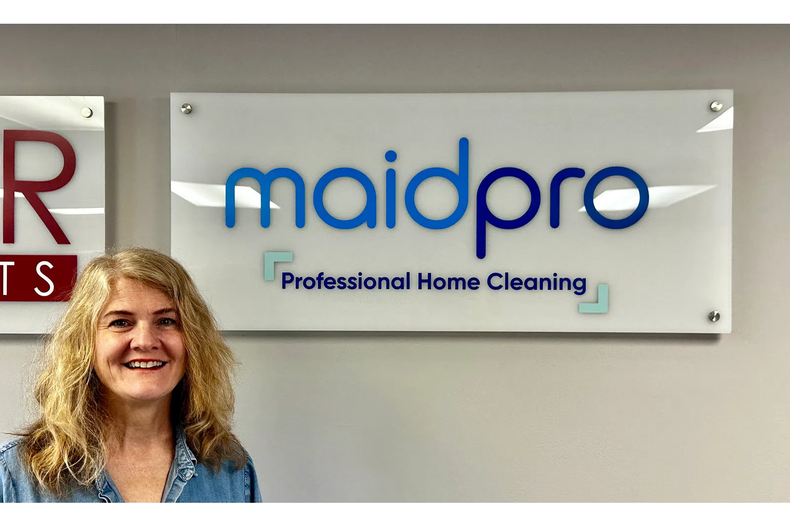 a person smiling in front of a sign