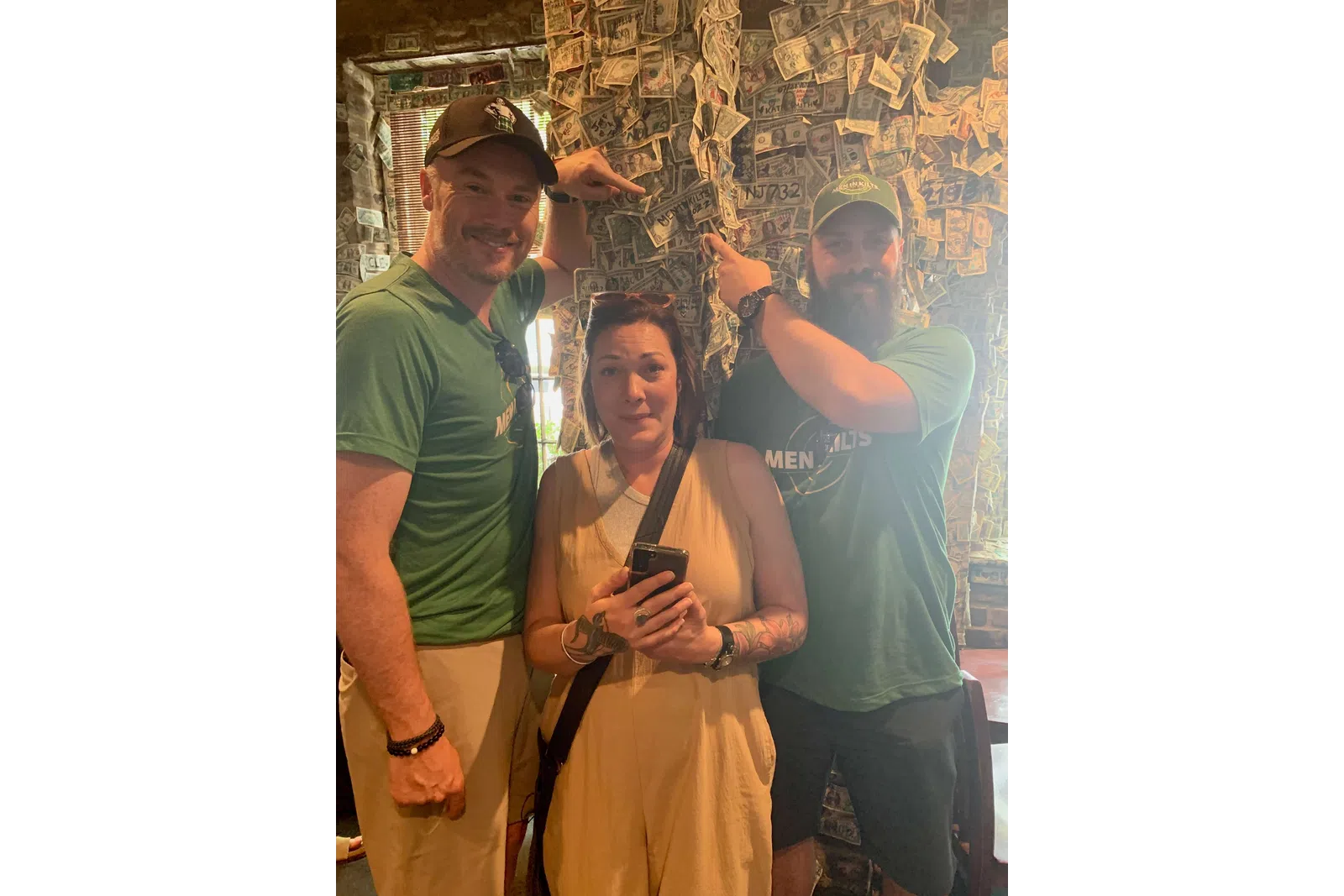a woman holding a phone and standing next to a man