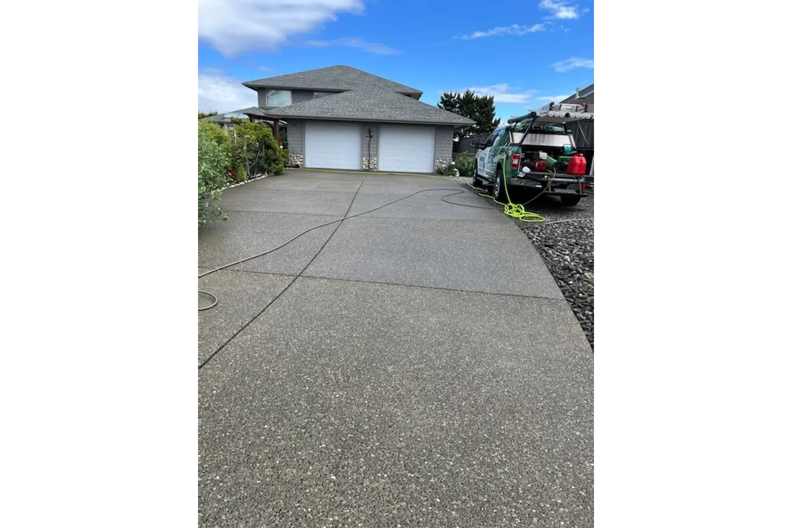 a driveway with a house and a tractor parked in the driveway