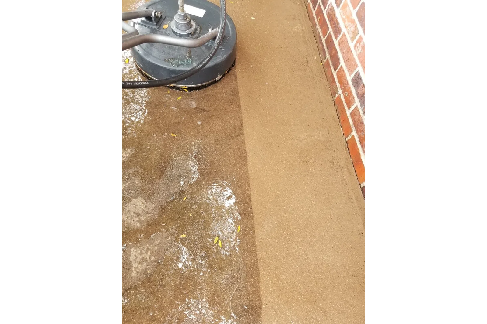 a dirty floor next to a brick wall