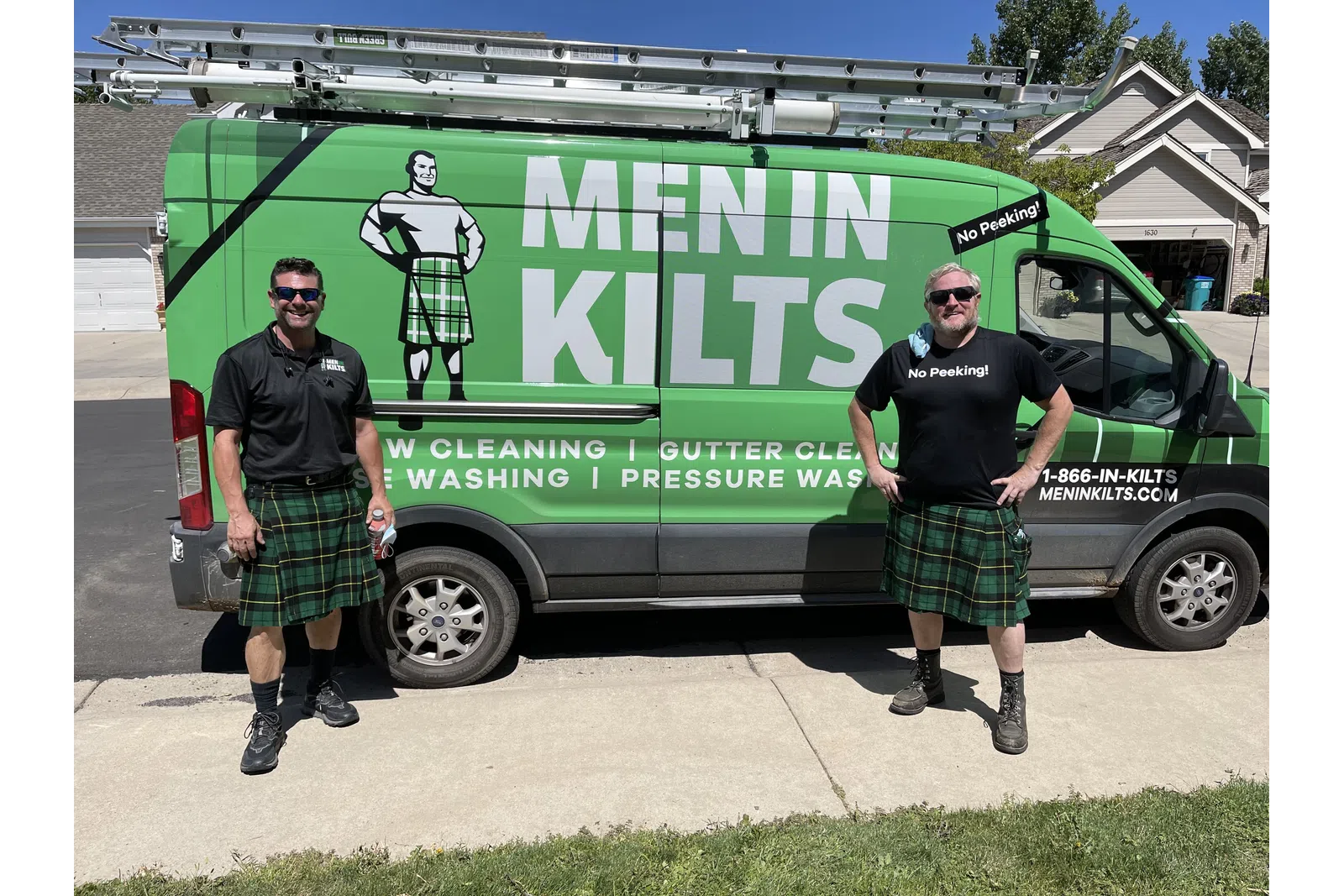 two men standing in front of a green van