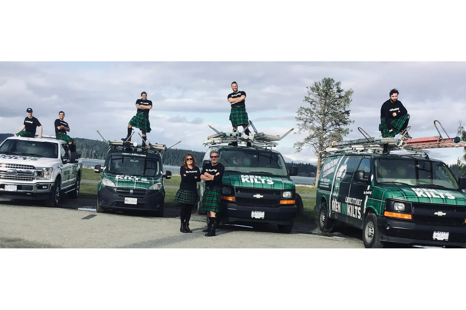a group of people standing next to a group of cars