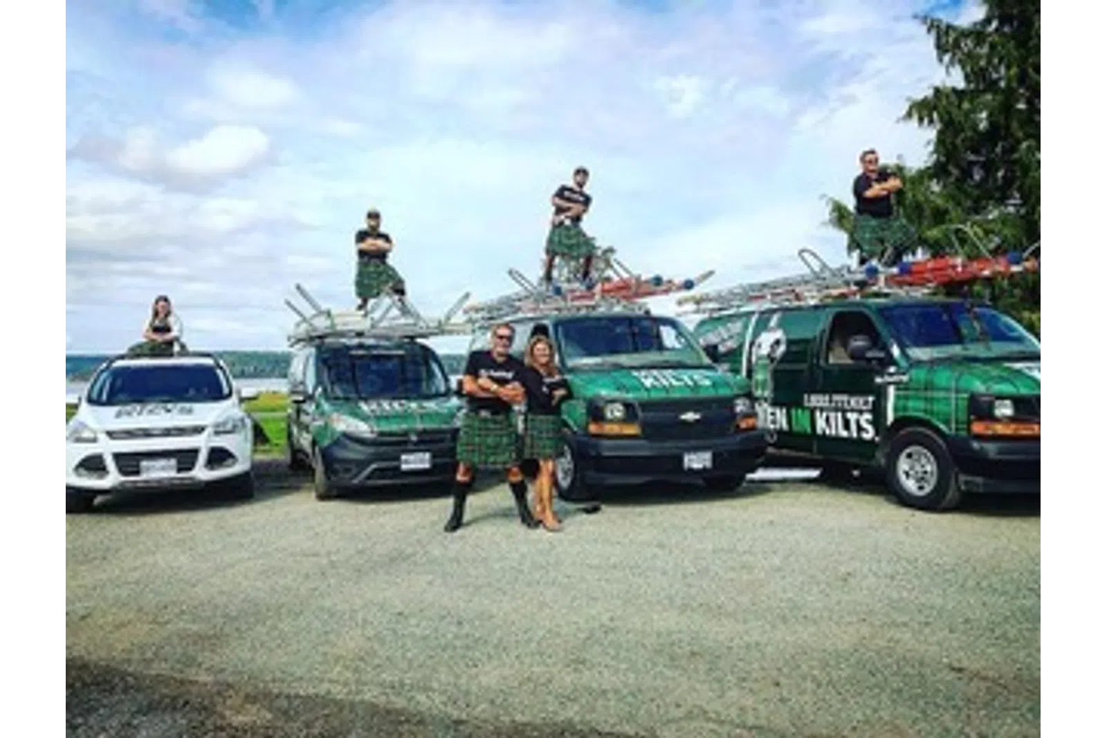 a group of people standing next to a row of cars