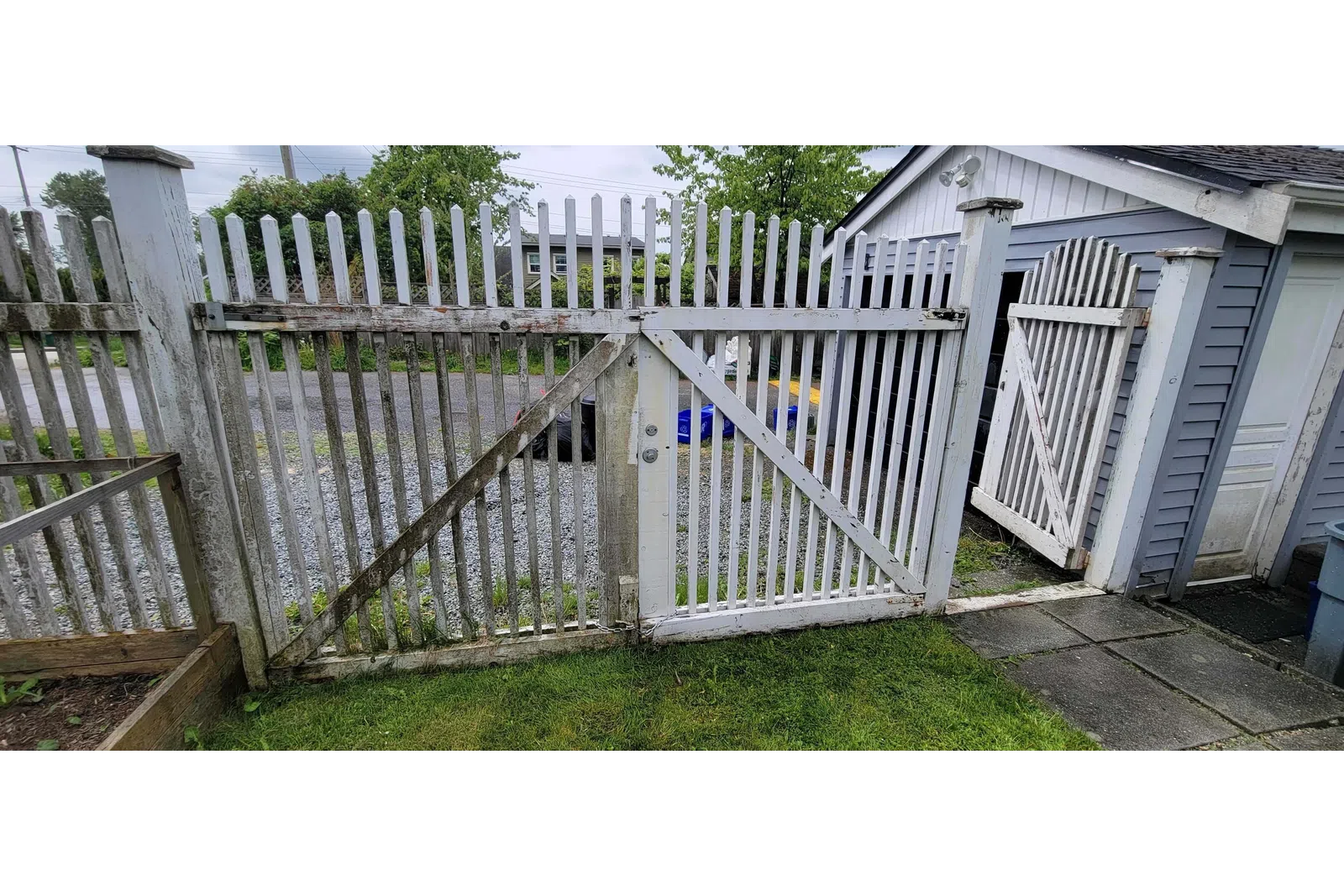 a white fence with a metal gate