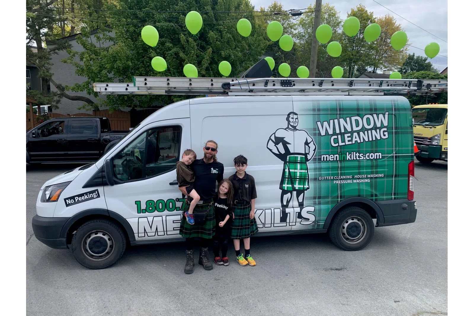 a group of people posing for a photo in front of a van