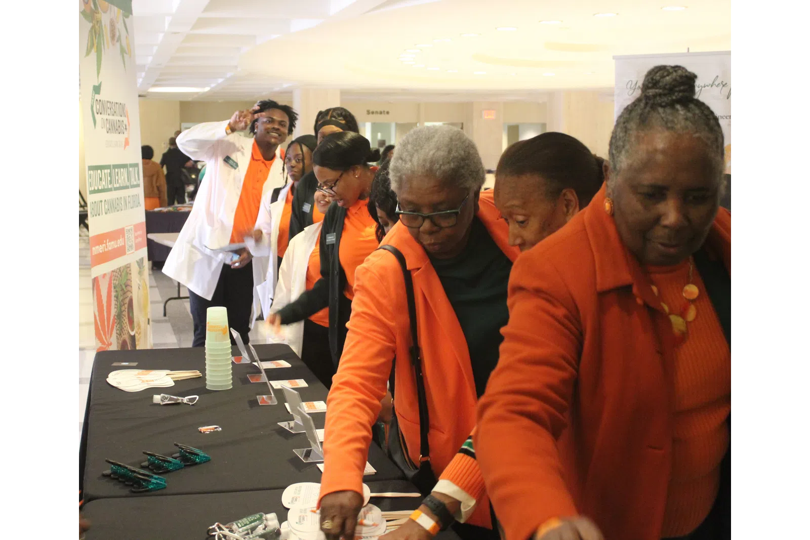 a group of people in orange vests looking at a paper