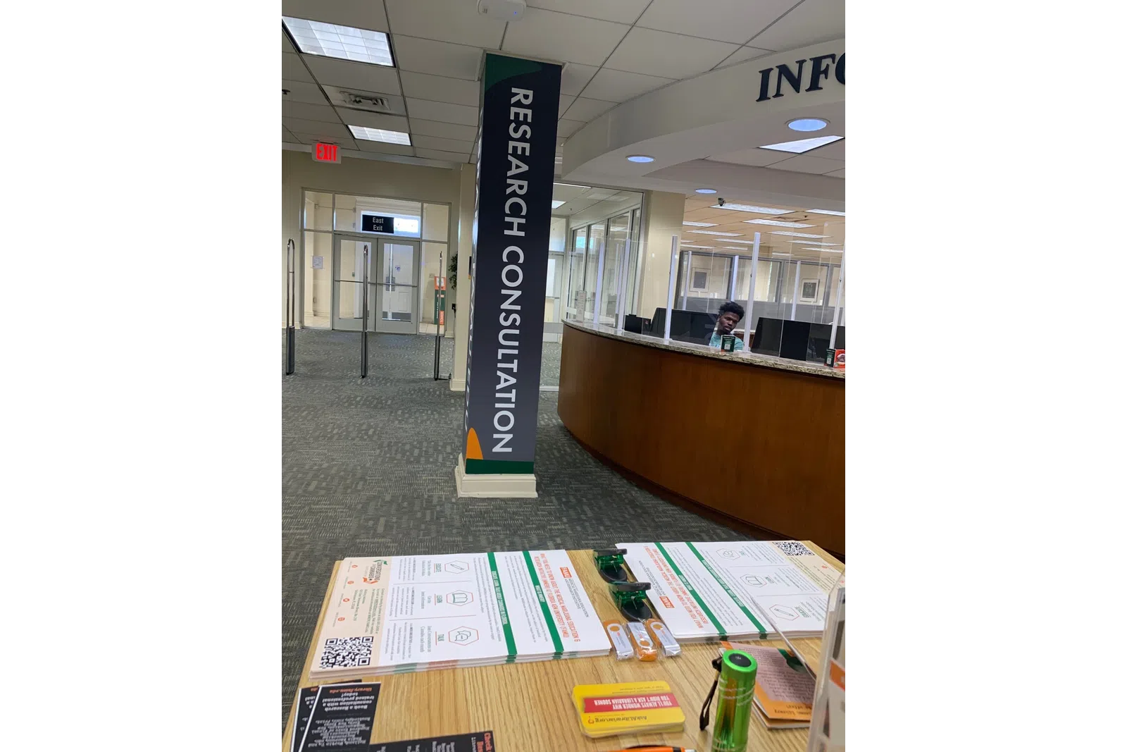 Research consultation area in a modern office with information desk, brochures, and glass partitions.