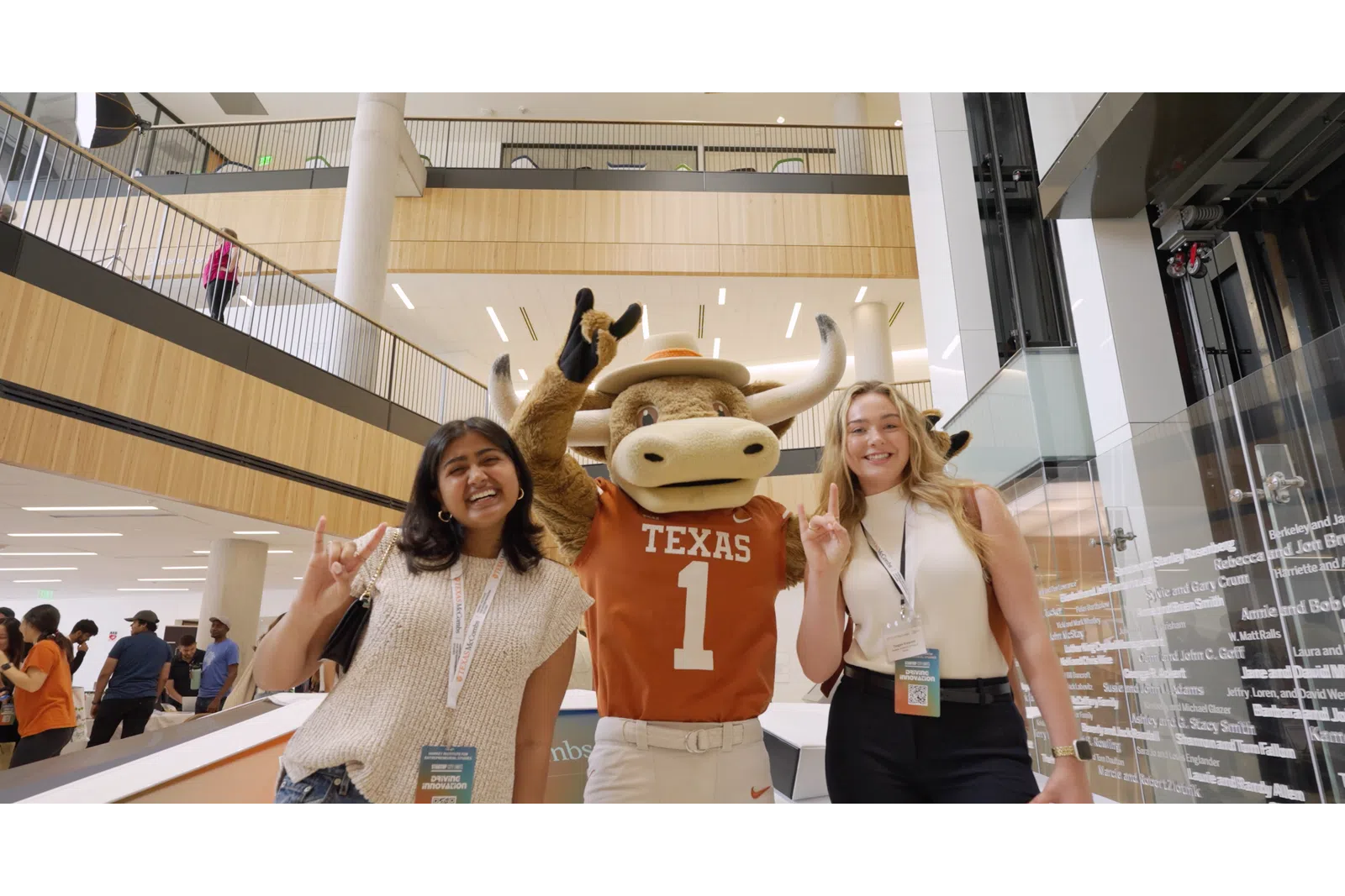 a couple of women posing with a mascot