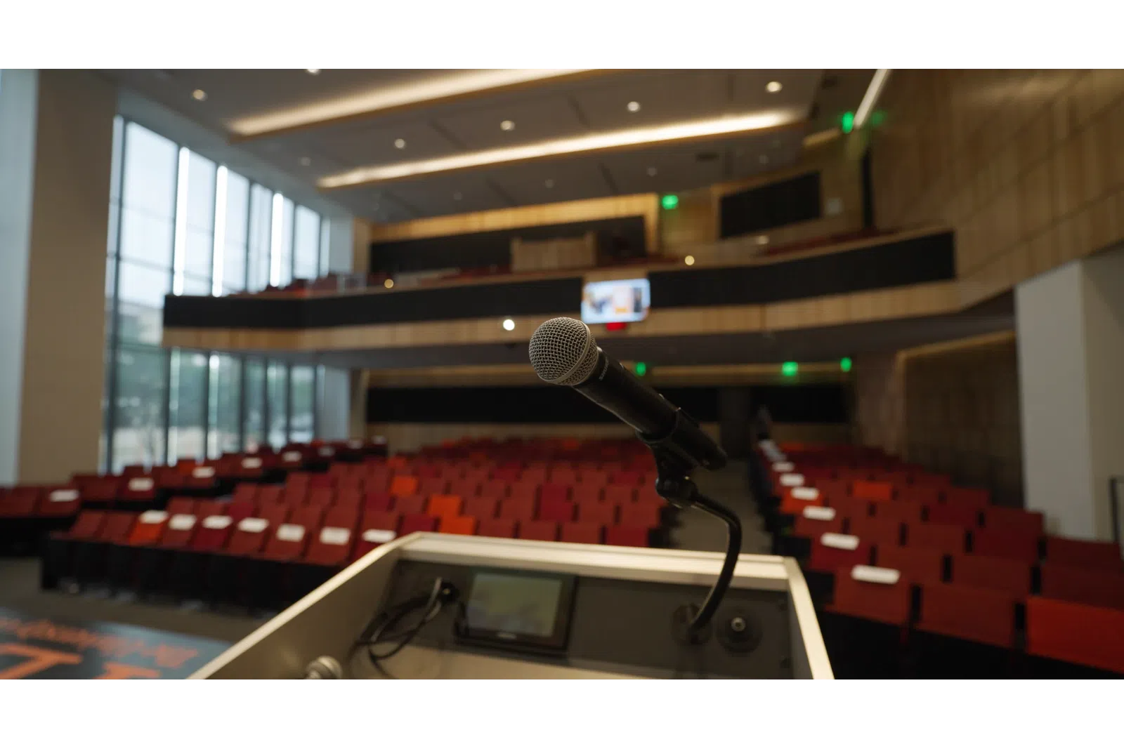 a microphone on a podium in a room with red seats