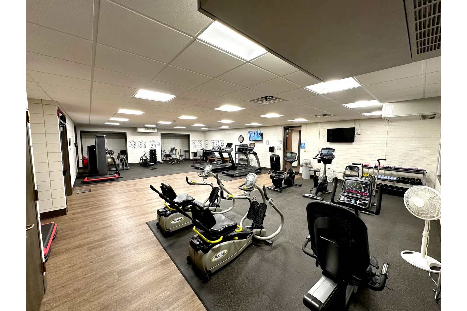 a large room with treadmills and chairs