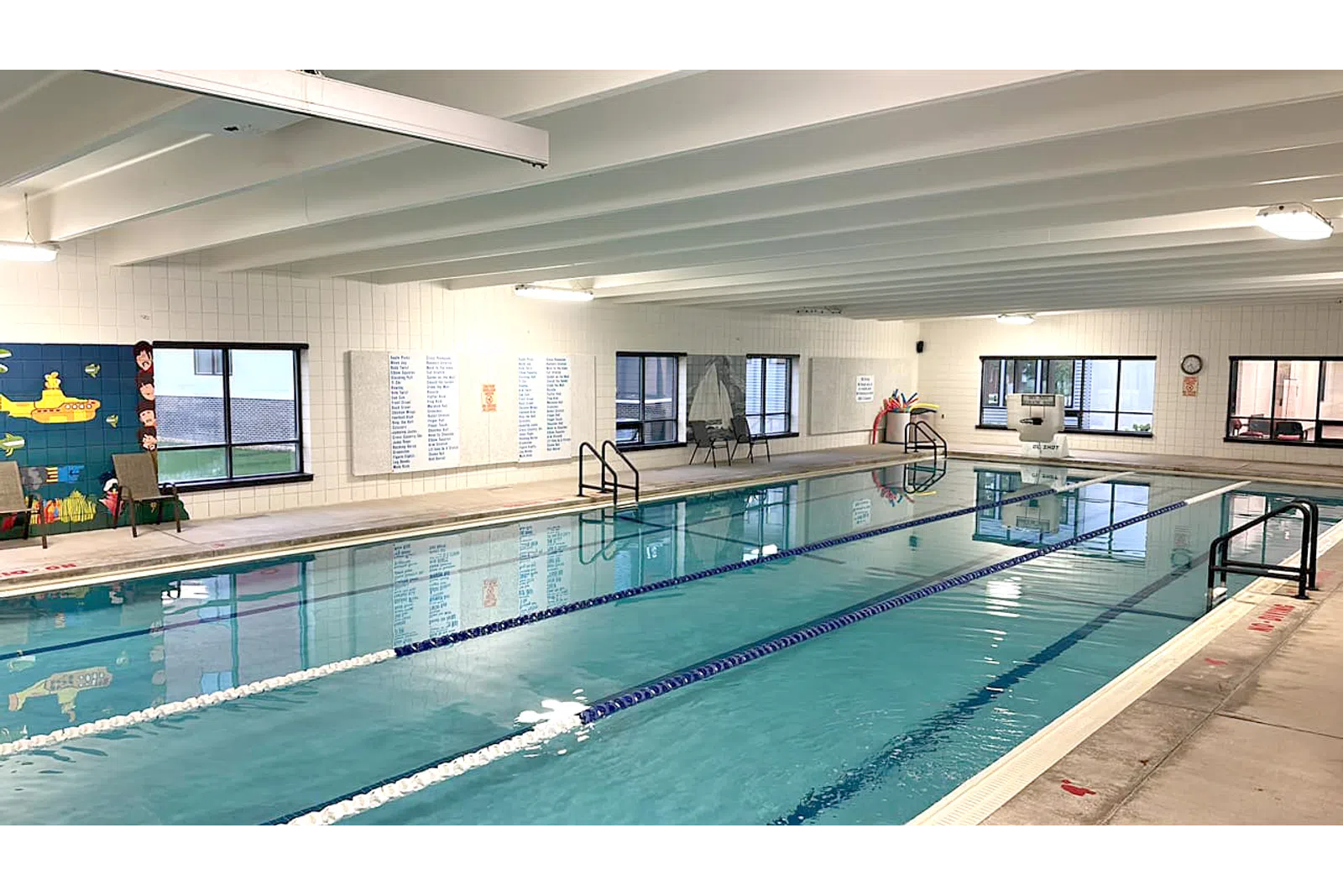 Indoor swimming pool with lanes, bright lighting, and a clean environment for recreational use.