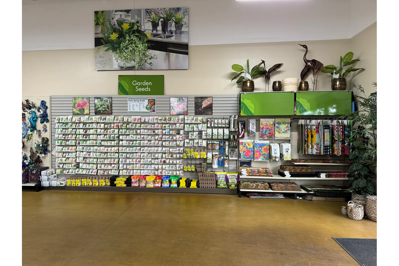 Indoor garden center display with various seed packets, gardening tools, decorative plants, and accessories.