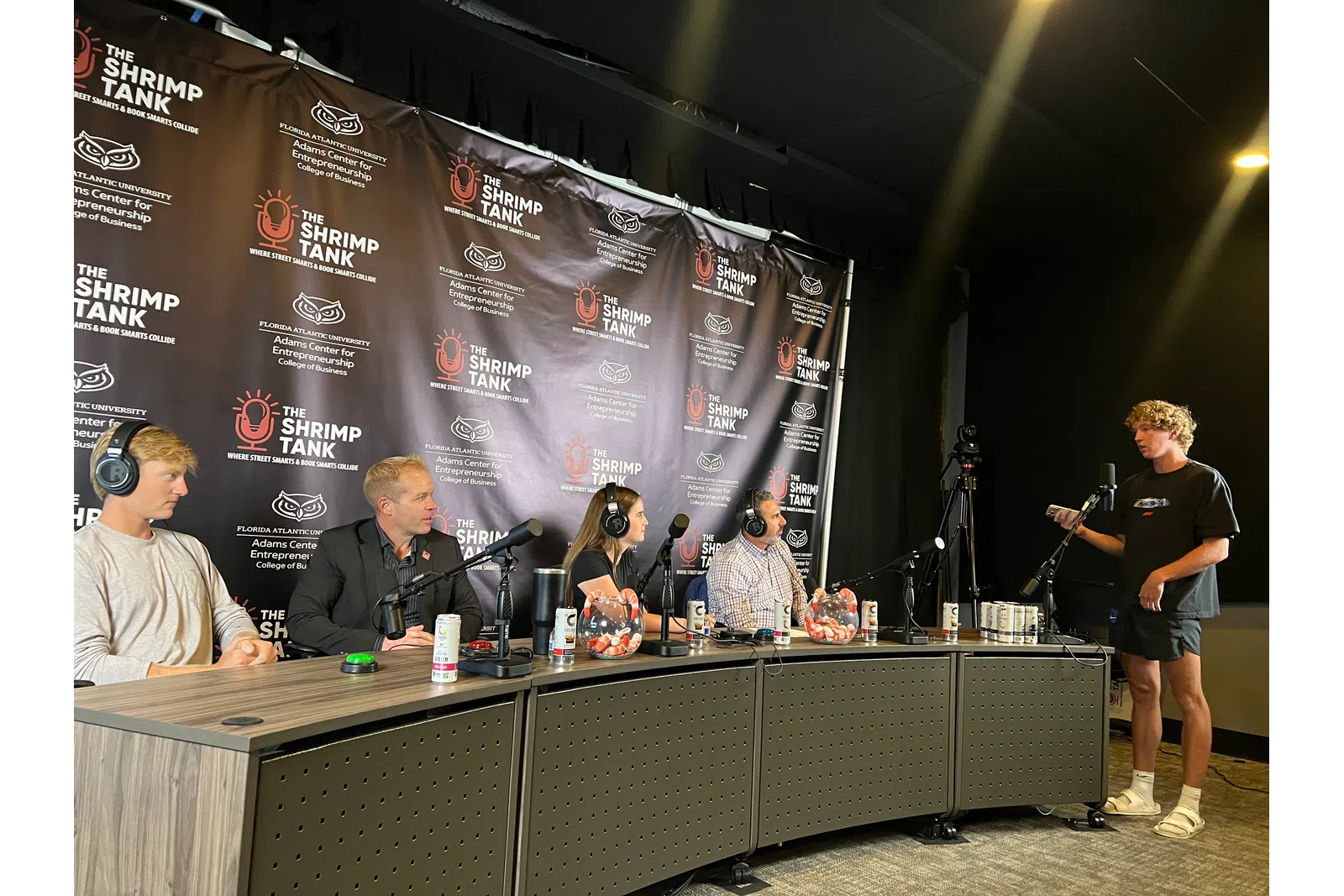 Panel discussion at The Shrimp Tank event with hosts and speaker in a podcast studio setup.