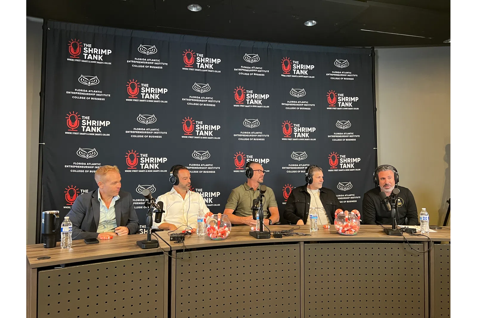 Five men seated at a podcast table with microphones in front of a backdrop with The Shrimp Tank and Florida Atlantic Entrepreneurship Institute logos.