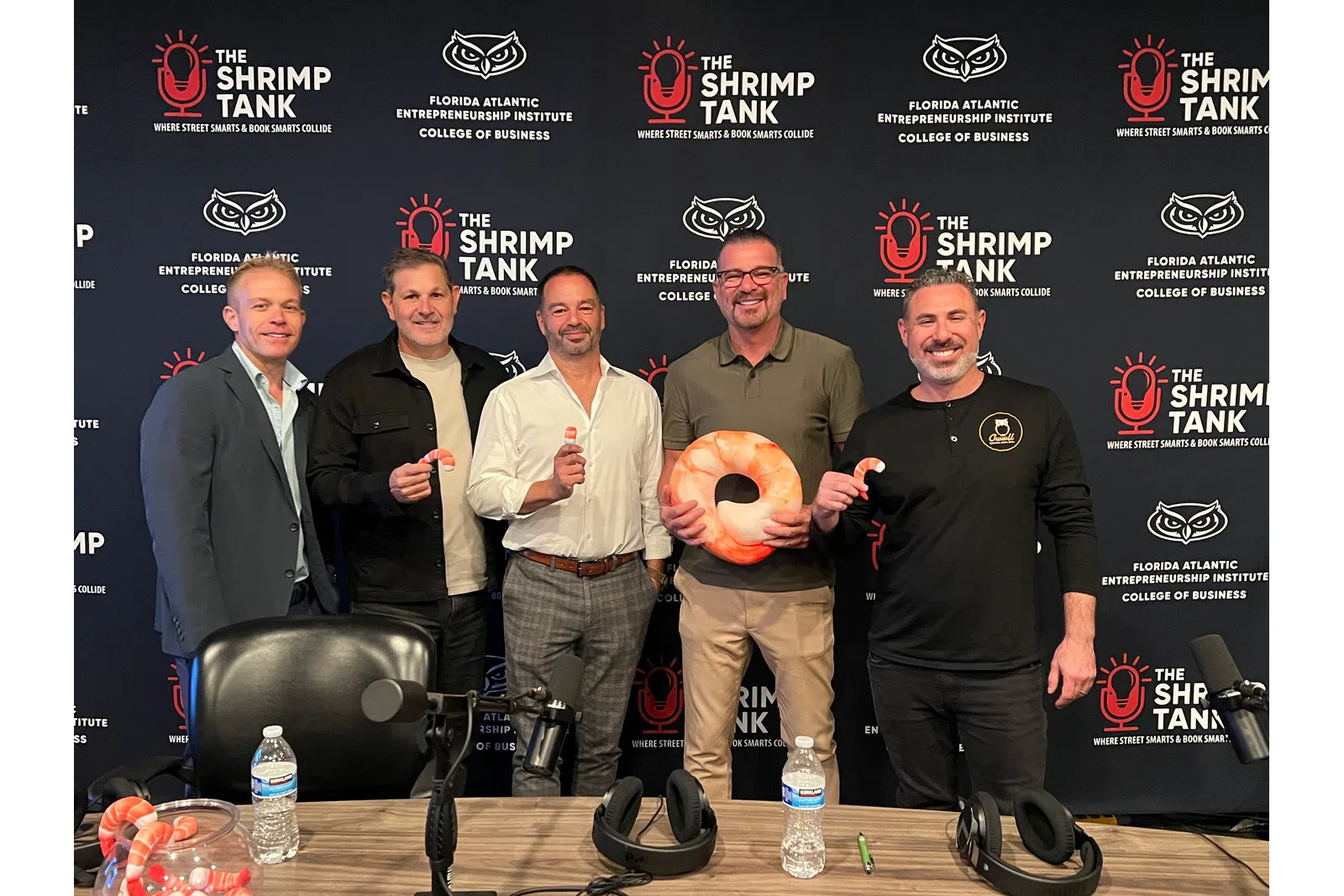 Five men smiling in front of a backdrop branded with The Shrimp Tank and Florida Atlantic Entrepreneurship Institute logos with overlaid text.