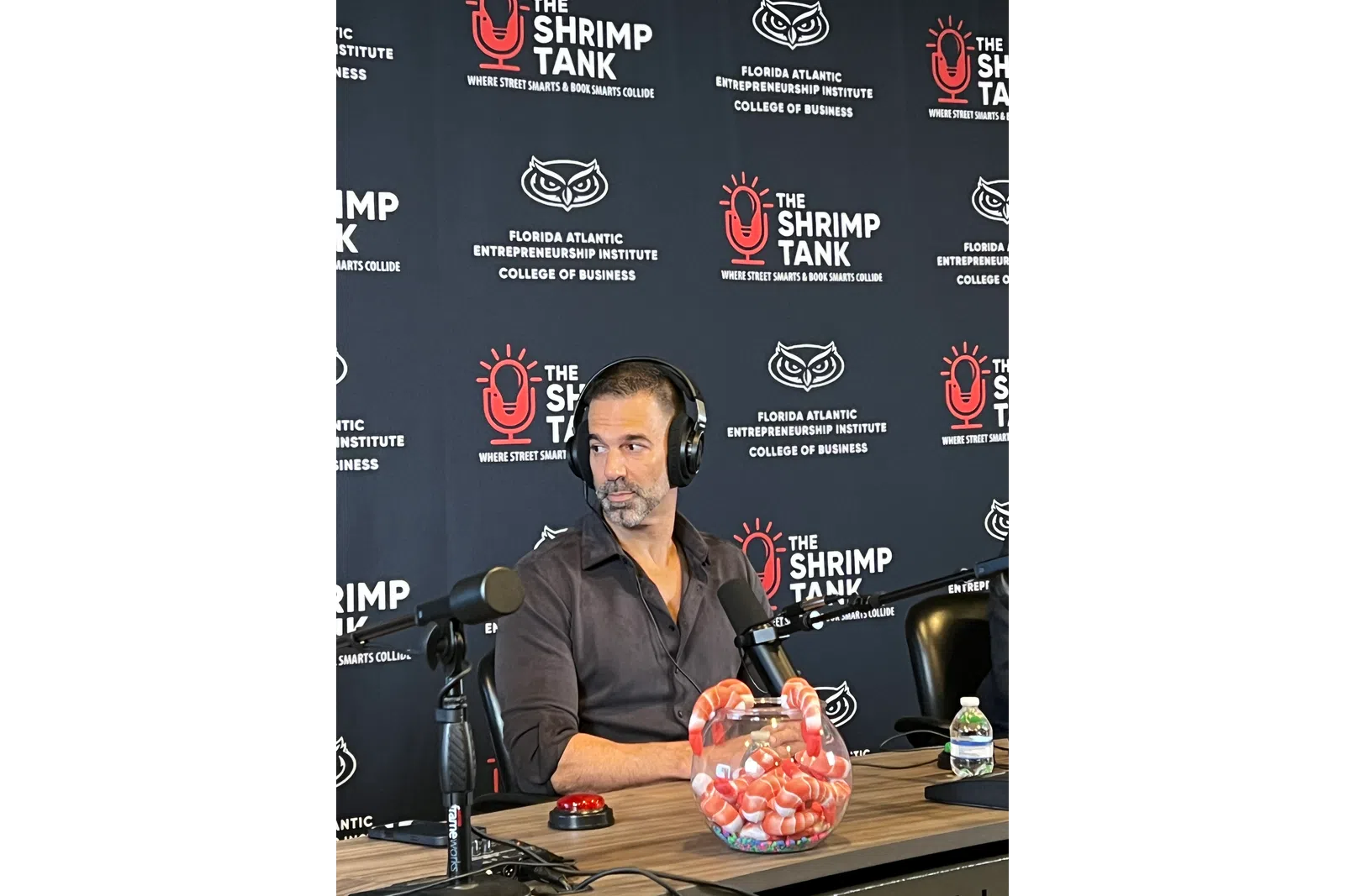 Man wearing headphones speaking into microphone during The Shrimp Tank podcast at Florida Atlantic Entrepreneurship Institute