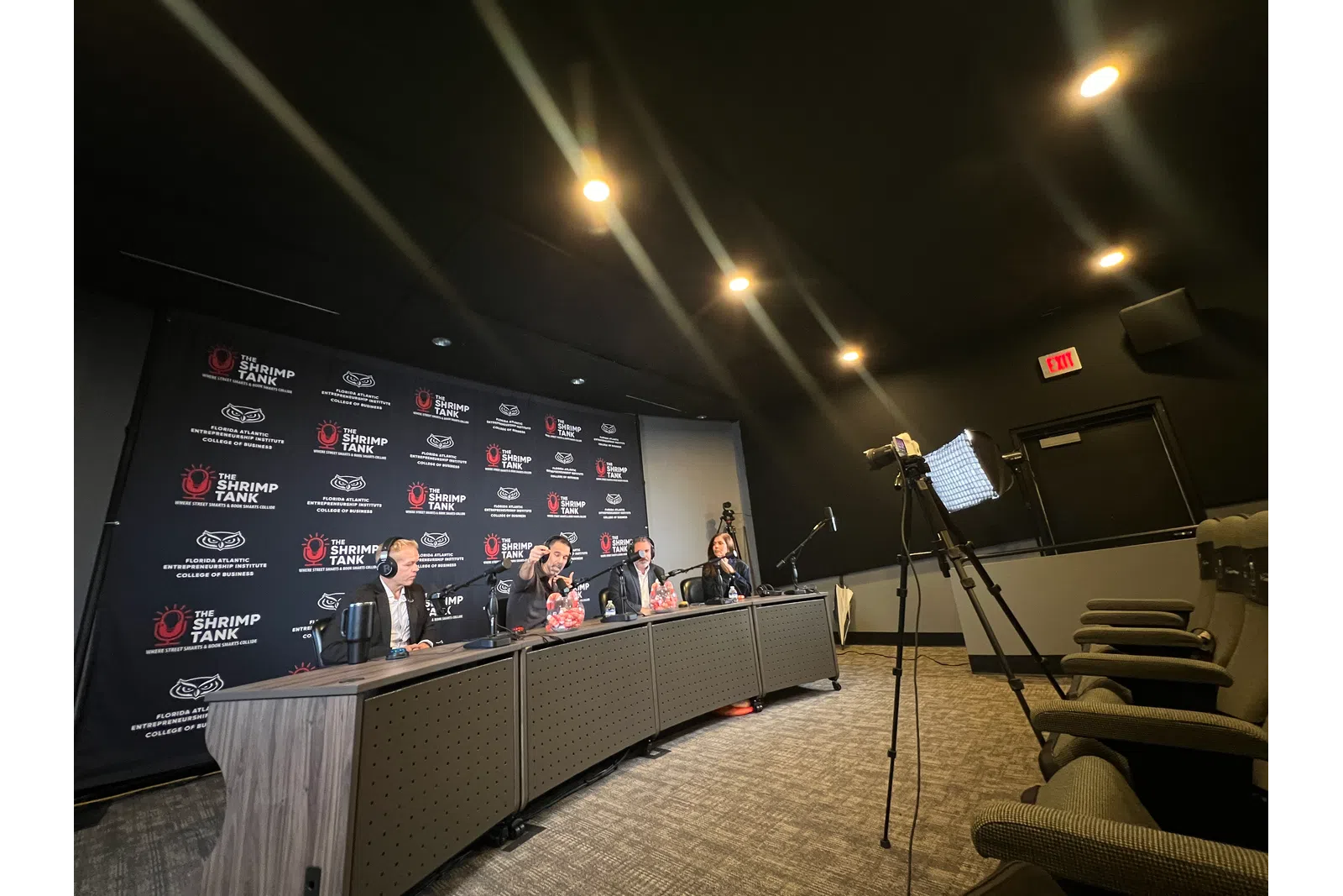 Panel of four judges at The Shrimp Tank event seated at a desk with microphones in a conference room.