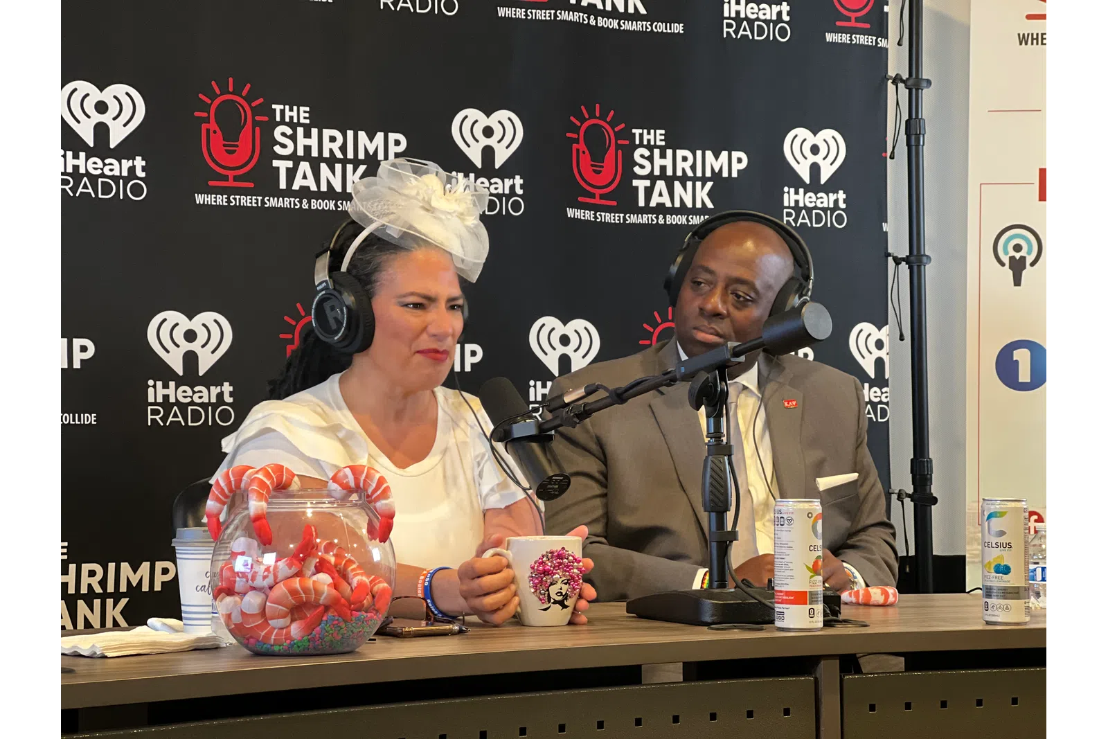 a man and woman sitting at a table with microphones