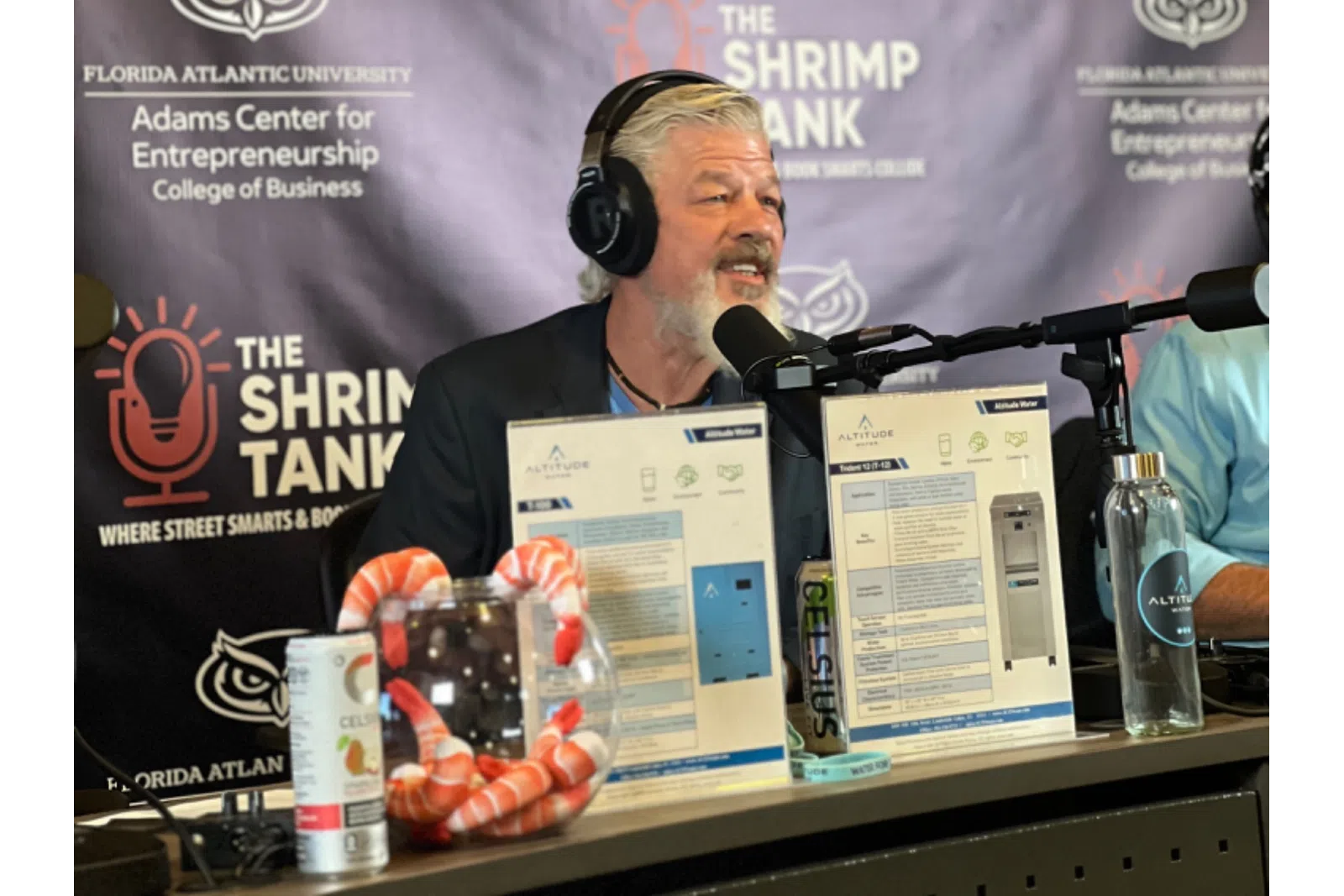 A speaker presenting at The Shrimp Tank event, showcasing entrepreneurial ideas and products.