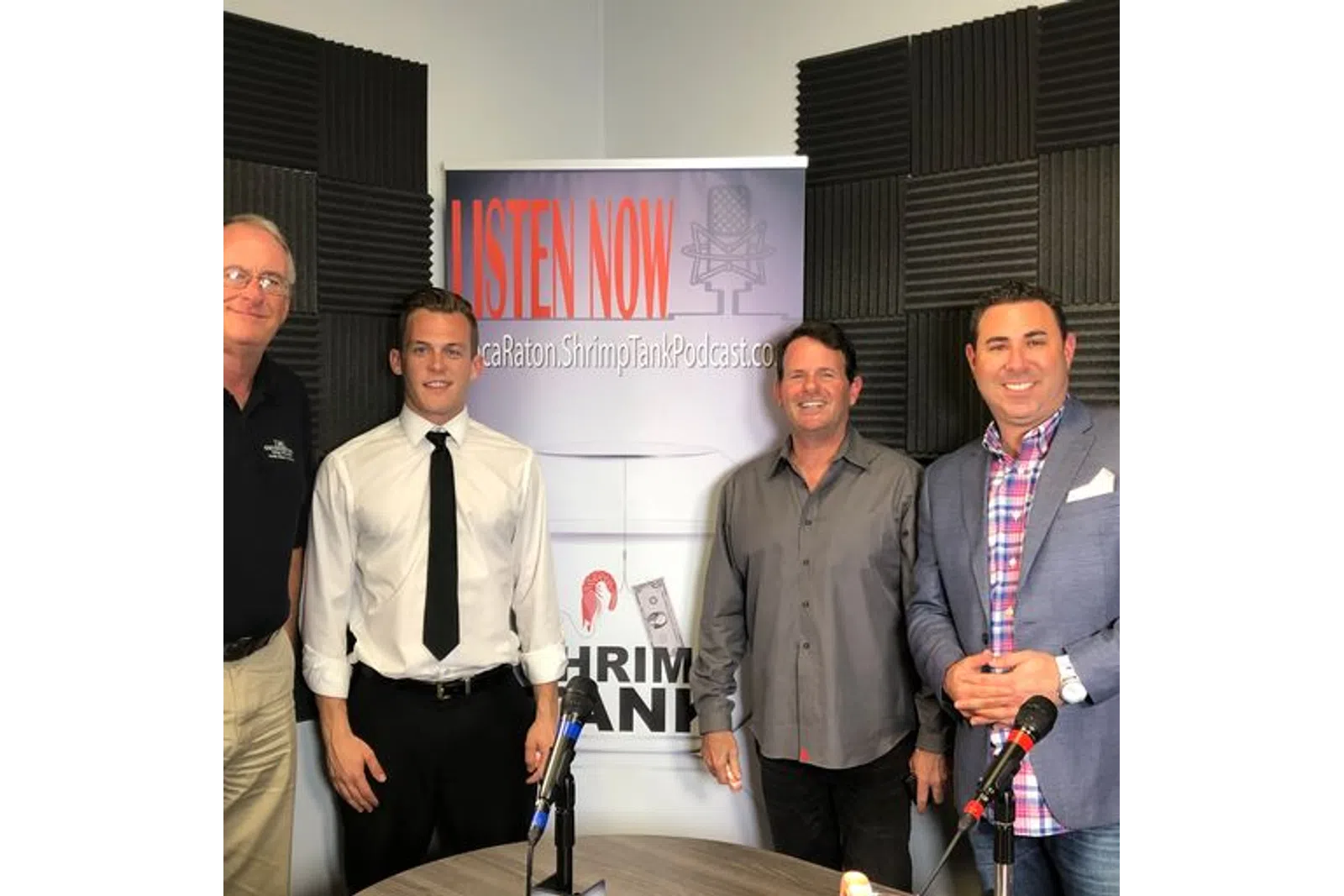 a group of men standing in front of a sign
