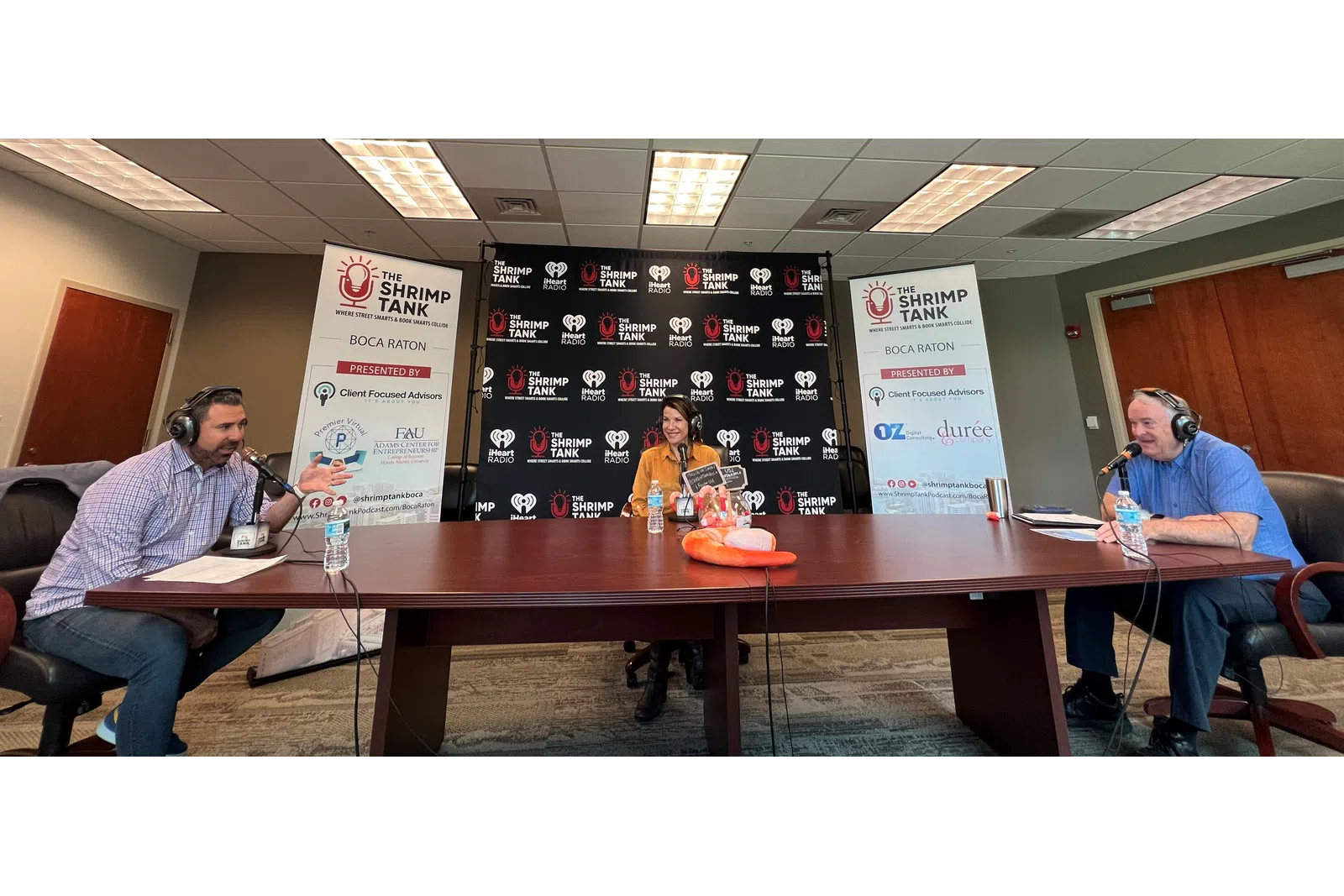 a group of people sitting at a table with microphones