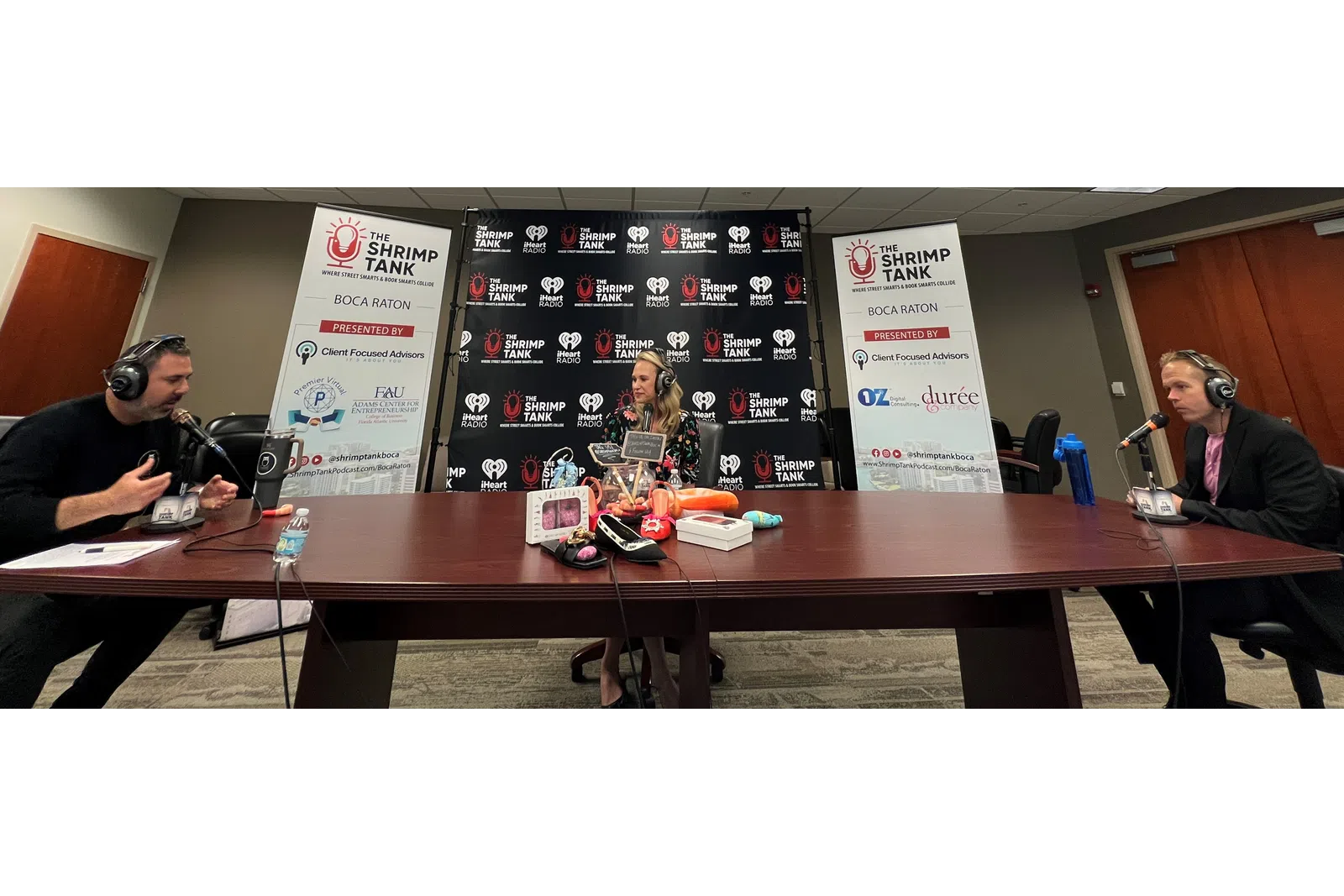 a group of people sitting at a table with microphones