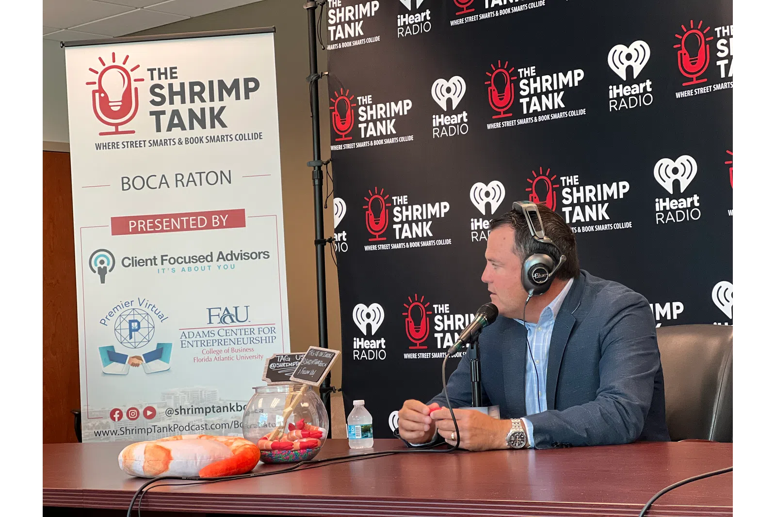 a person wearing headphones and sitting at a table with a microphone