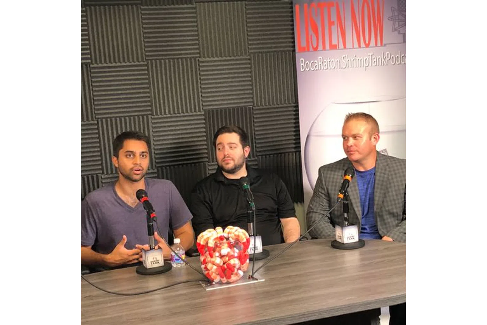 a group of men sitting at a table with drinks and food