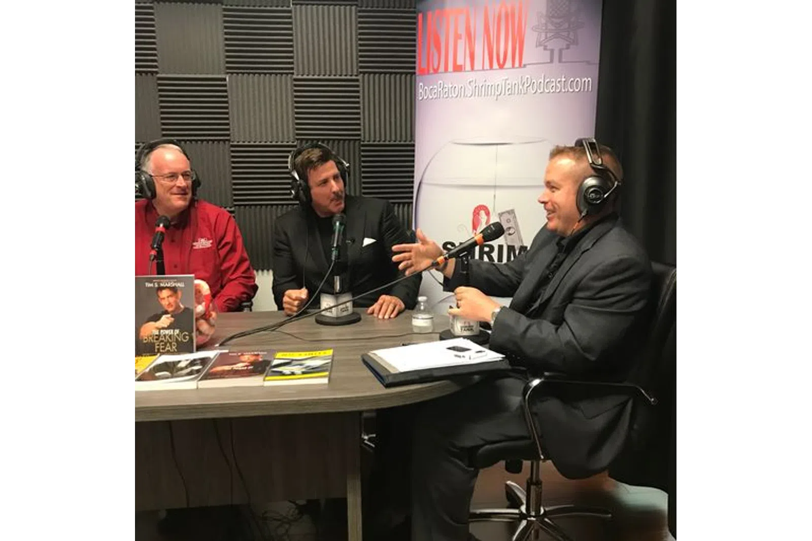a group of men sitting at a table with microphones