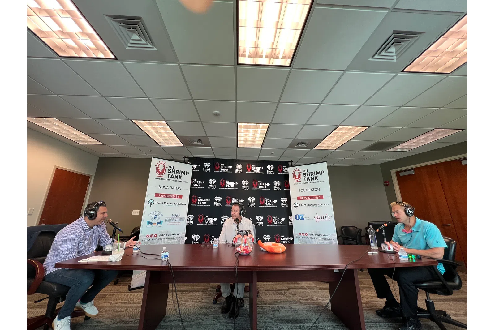 a group of people sitting at a table with a sign in front of them