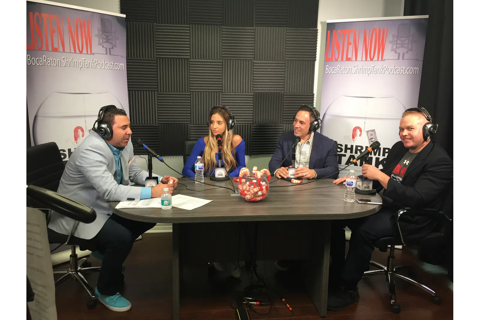 a group of people sitting at a table with microphones