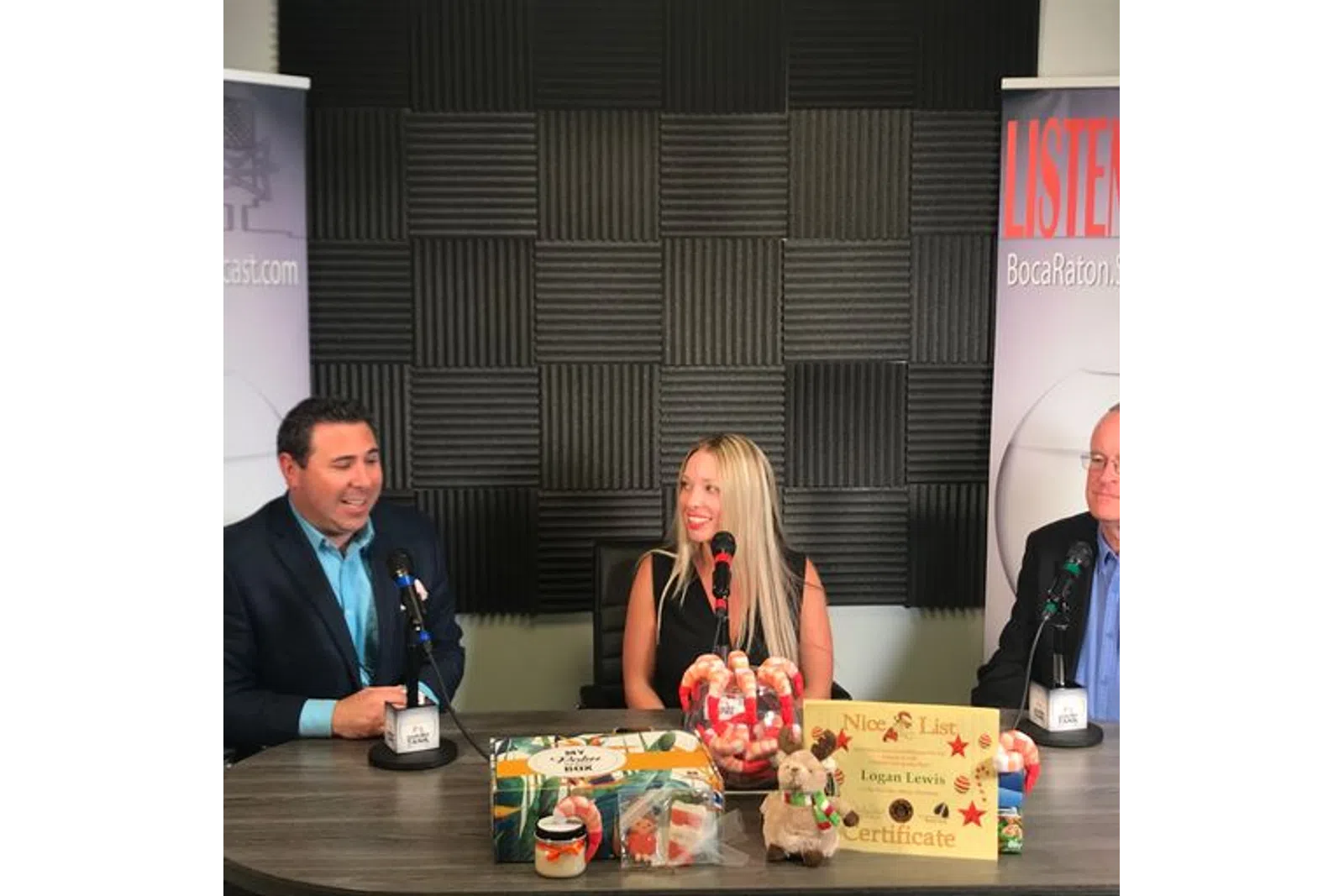 a group of people sitting at a table with microphones and food